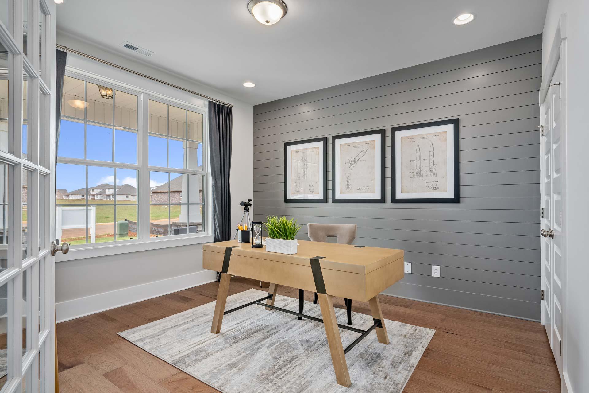 Modern home office in Kendall Downs Toney Alabama with wooden desk gray shiplap walls and large windows