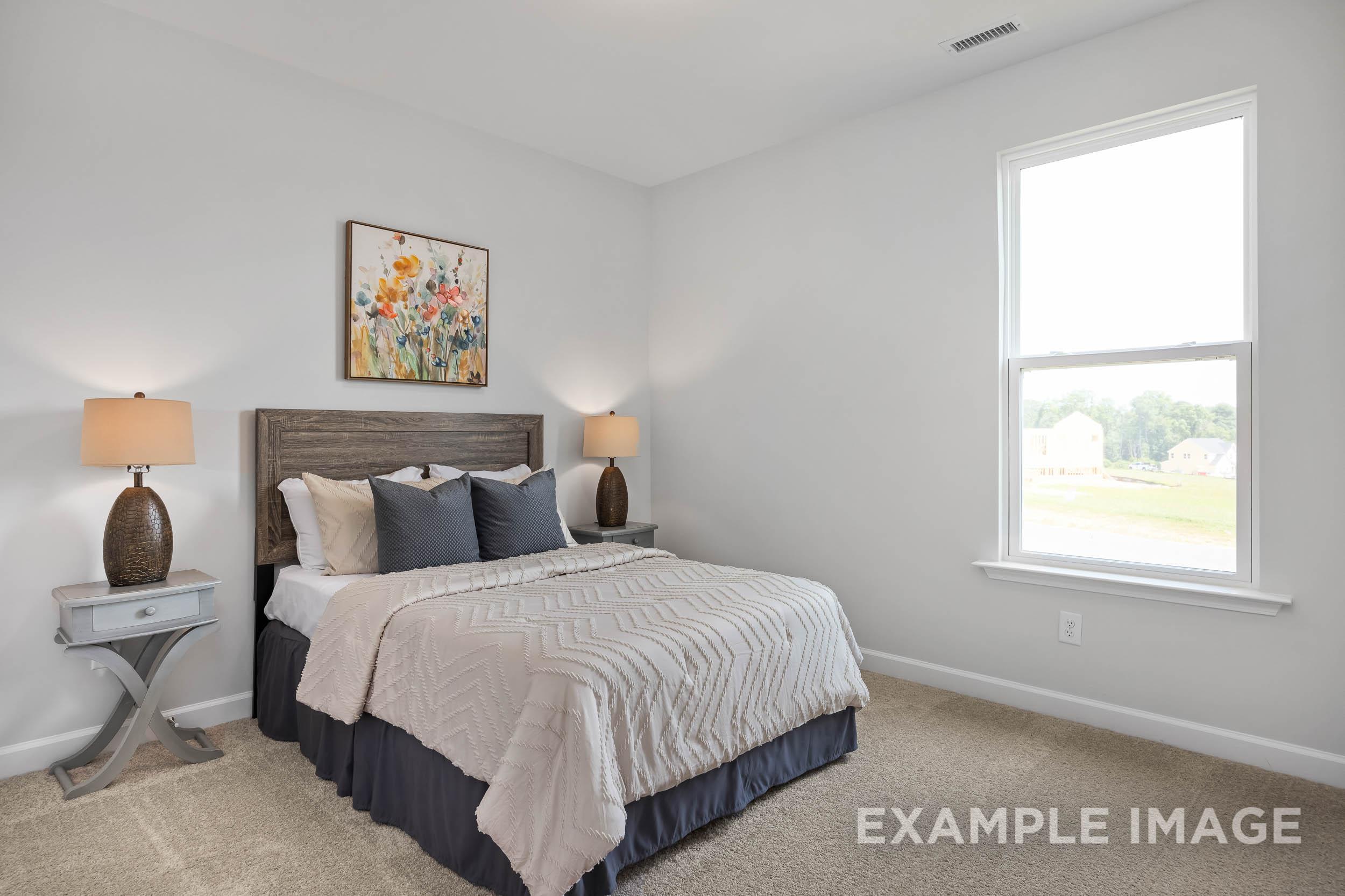 Cozy master bedroom in The Daphne C featuring queen bed with neutral bedding, wooden headboard, lamps, floral art, and large window