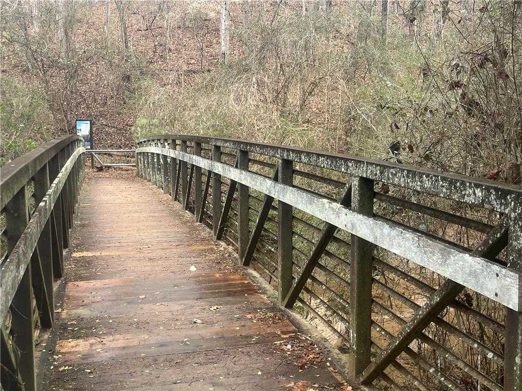 Scenic wooden footbridge with railings spanning wooded trail in Melody Lakeside Estates, Buford, Georgia