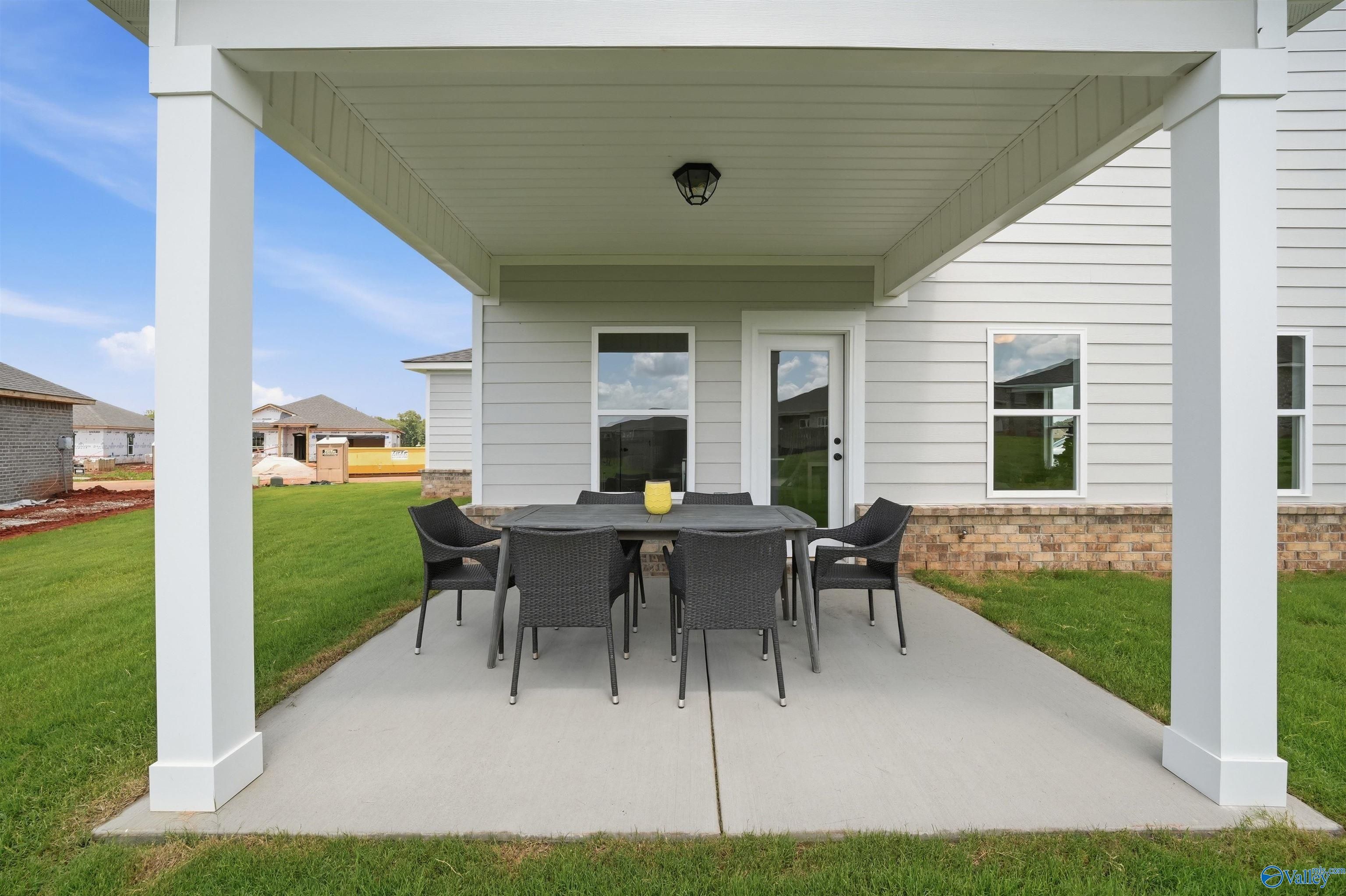 Covered back patio with dining set at The Burton B floor plan in Heritage Lakes, New Market, Alabama.