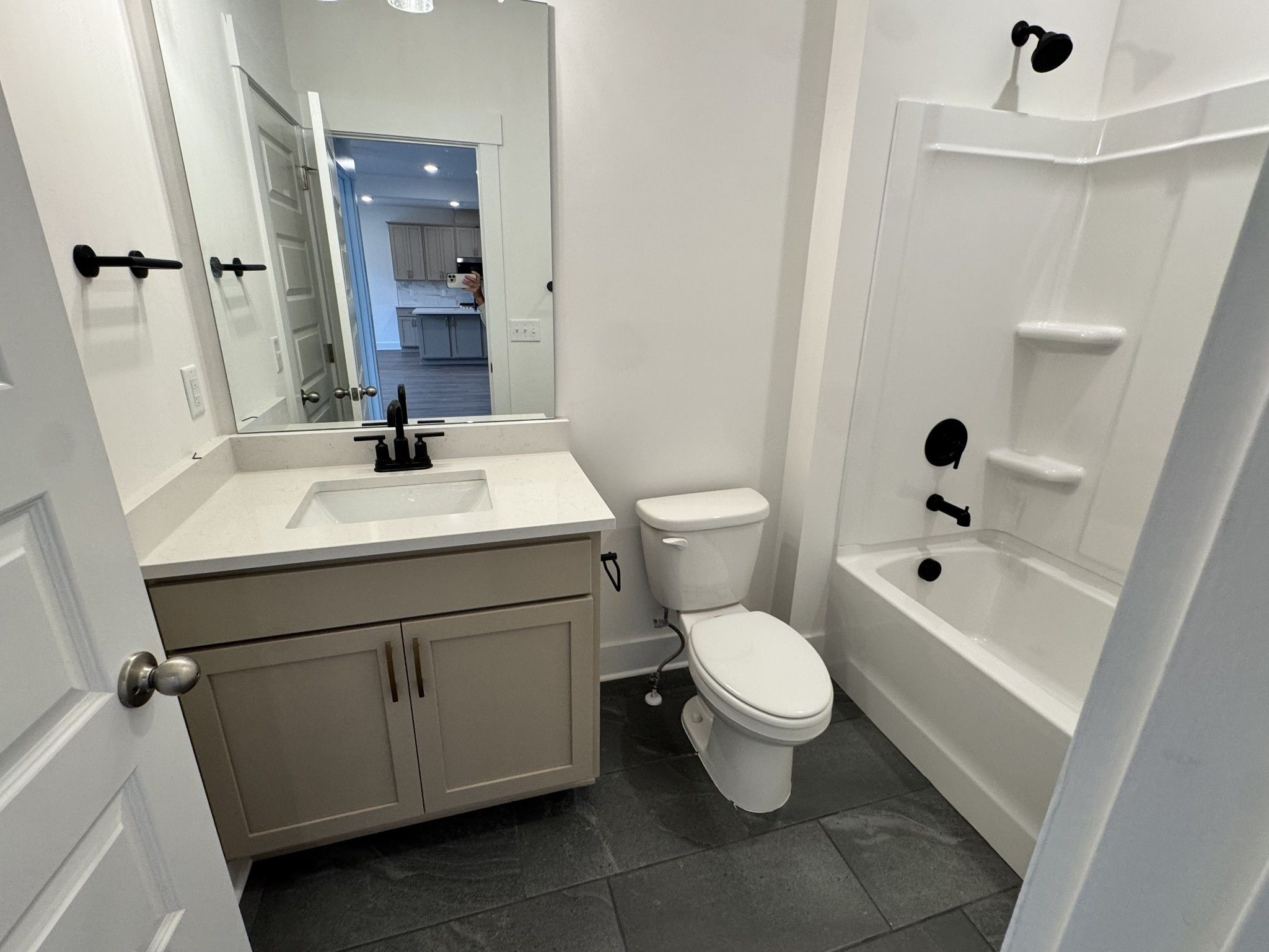 Modern bathroom with beige vanity, black fixtures, and tub shower in Davidson Homes The Willow B, Woods Crossing, Gallatin, TN