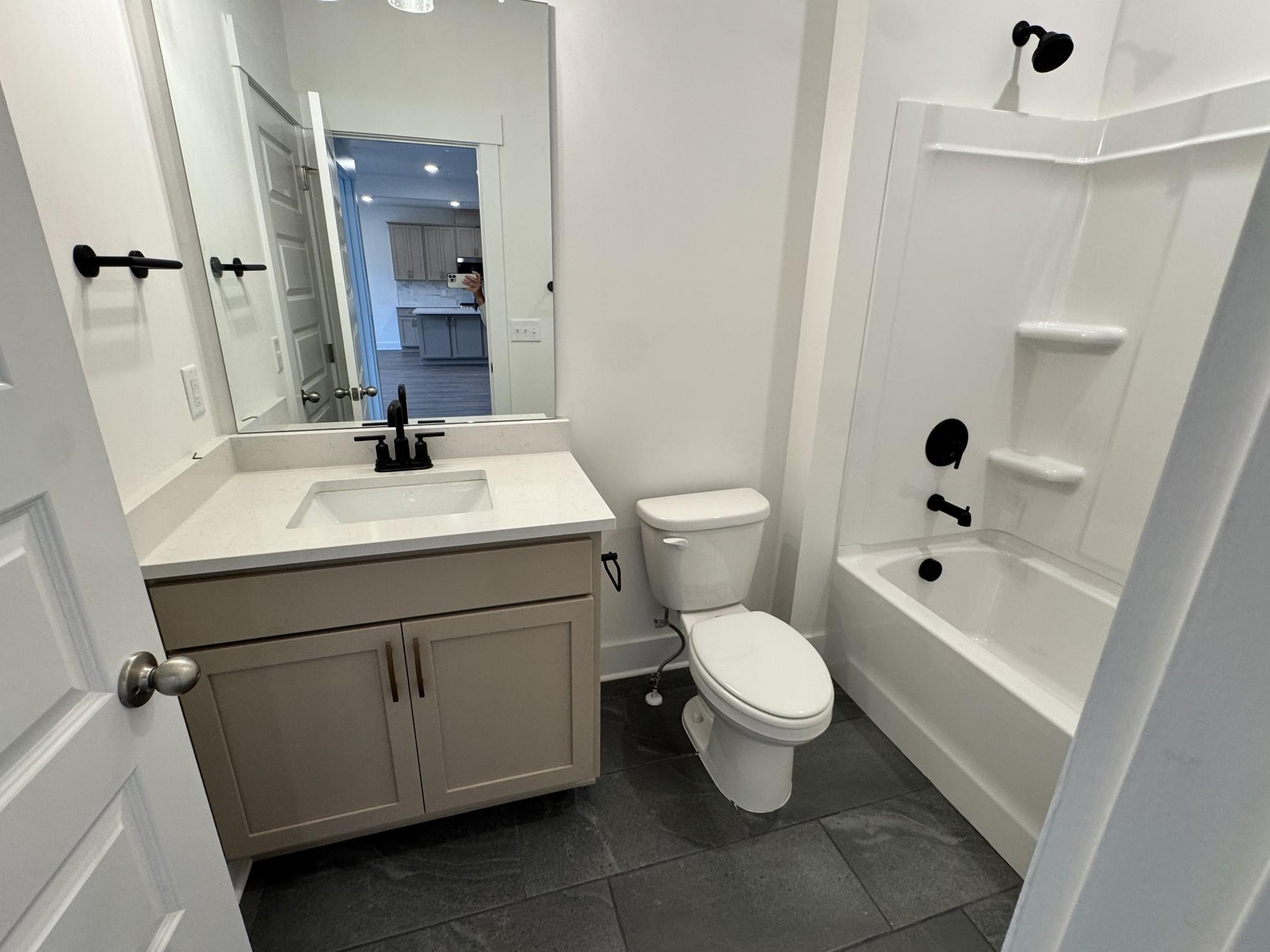 Modern bathroom with beige vanity, black fixtures, and tub shower in Davidson Homes The Willow B, Woods Crossing, Gallatin, TN