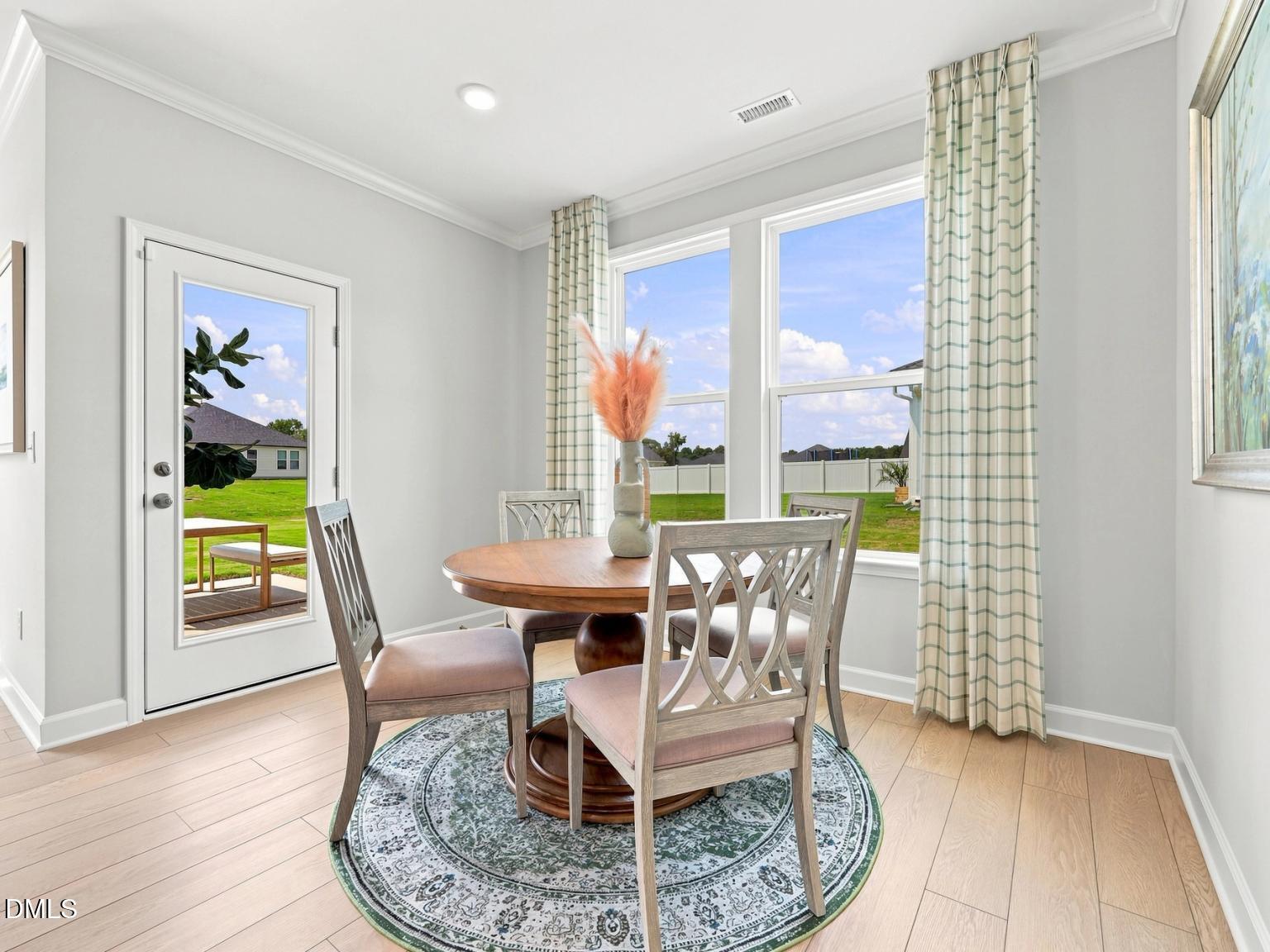 Bright breakfast nook with round wood dining table in The Daphne C floor plan at Woodland Crossing, Zebulon, NC.