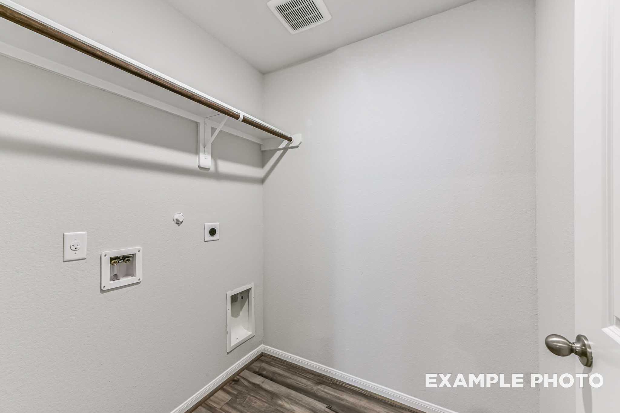 Laundry room in The Laguna A home featuring white walls, wooden hanging rod, utility sink hookups, dryer vent, and pet door