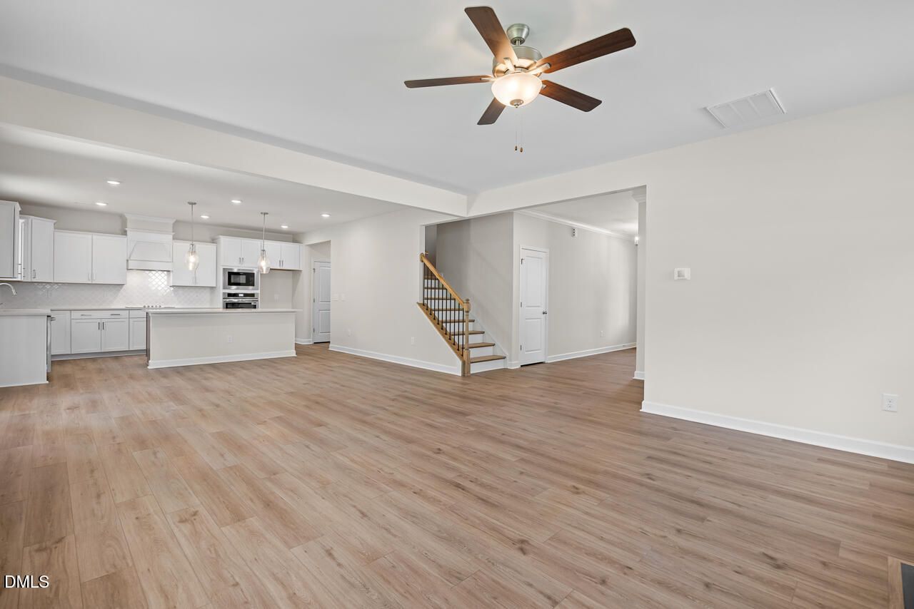 Open-concept living room and kitchen with white cabinetry in The Hickory II B floor plan, Montrose, Aberdeen, North Carolina.