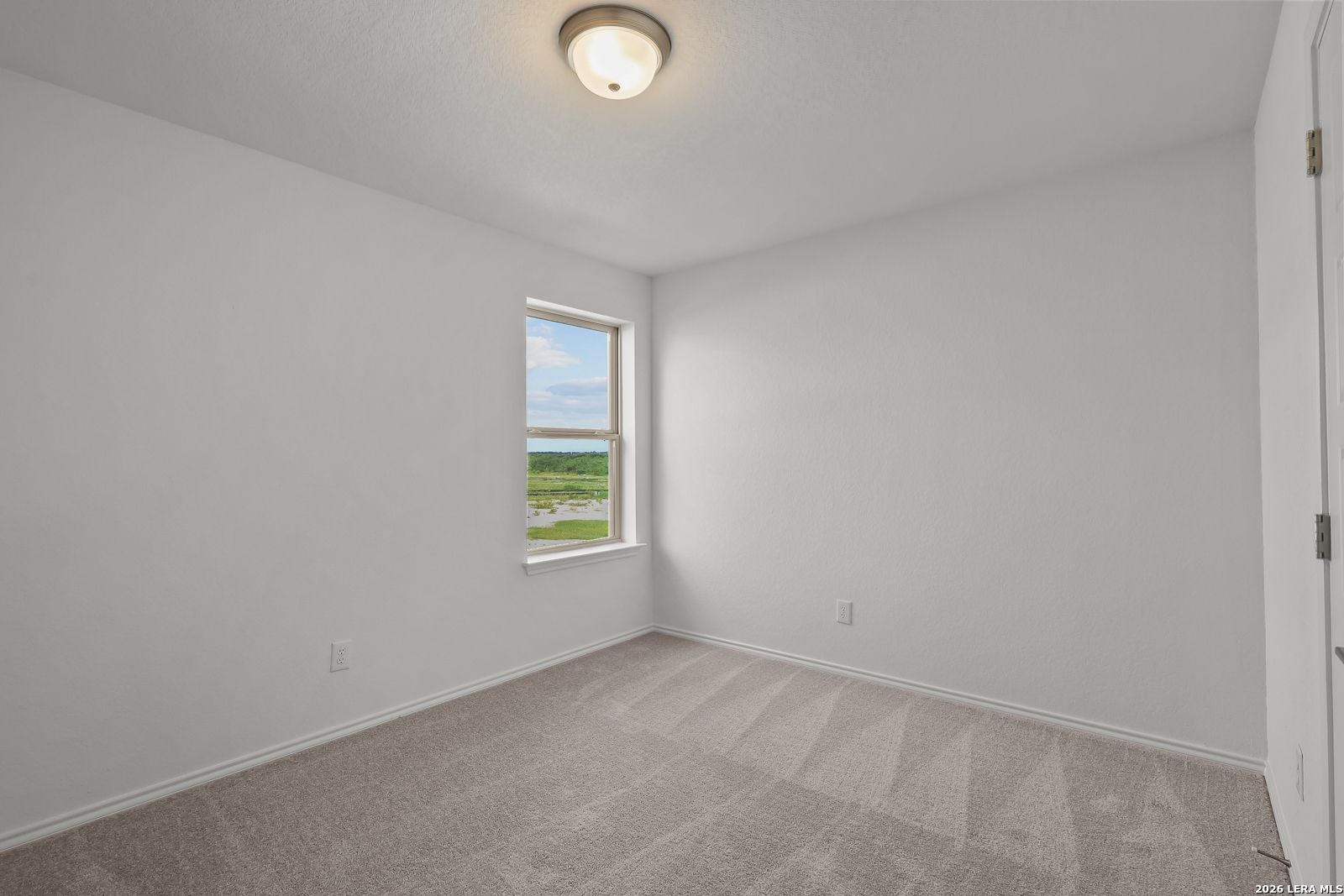 Bright, neutral bedroom with plush carpeting in The Brazos B floor plan at Davidson Homes in Agave, San Antonio, Texas.