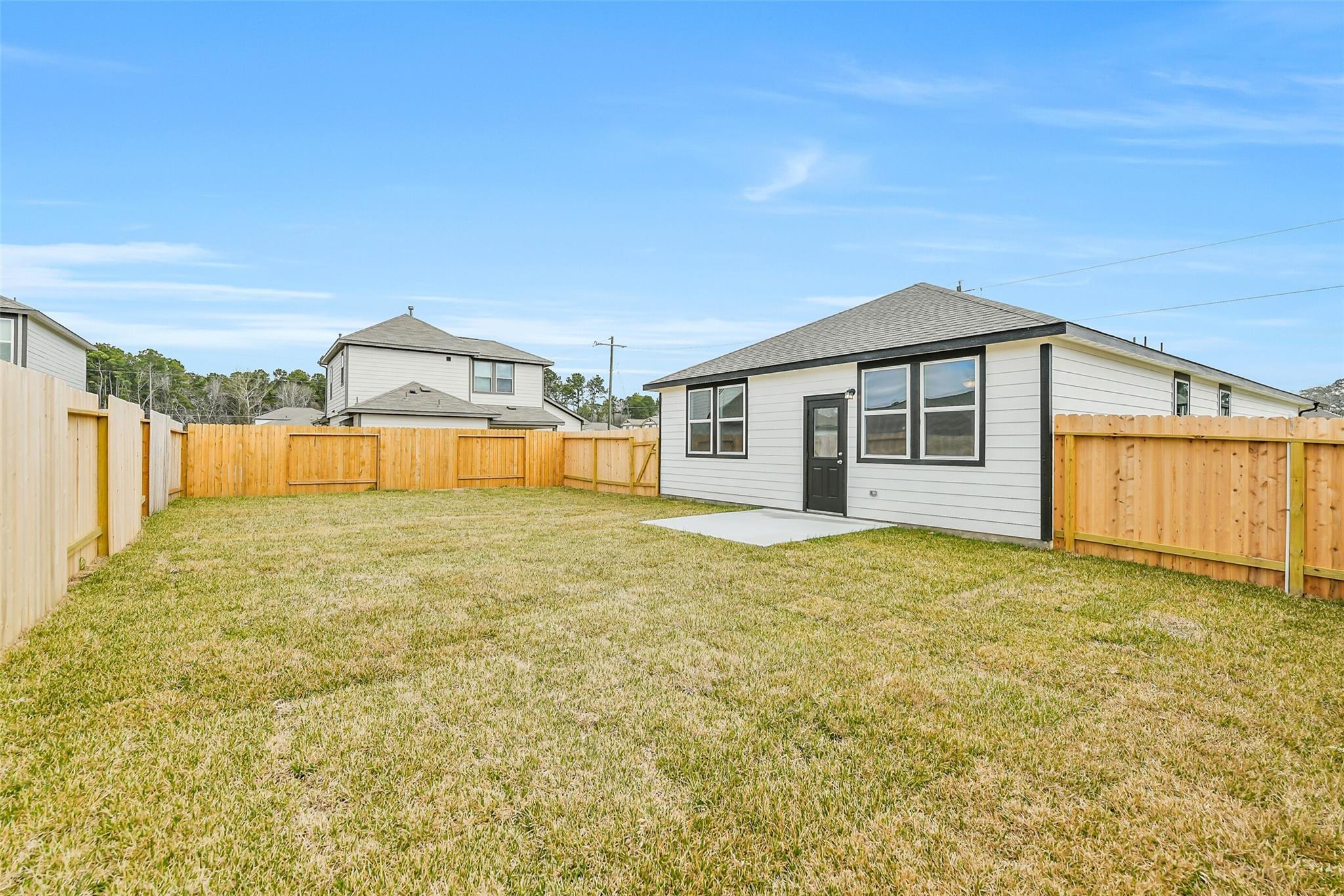 Backyard view of The Frio G single-story home with fenced grass yard, Davidson Homes in Liberty Estates, Cleveland, Texas