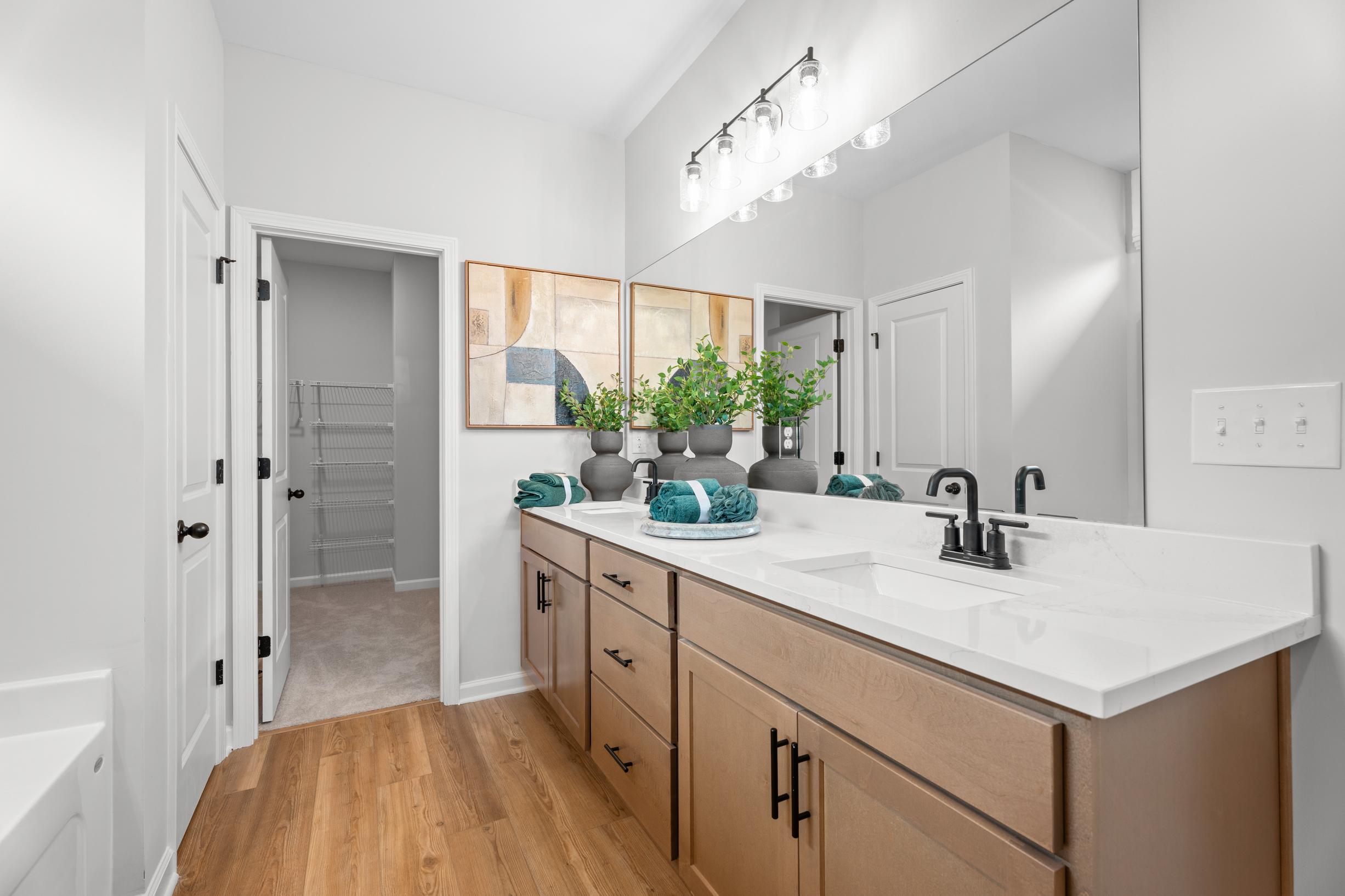 Modern bathroom with dual vanity and wood cabinets at Links Crossing in Auburn, Alabama by Davidson Homes.