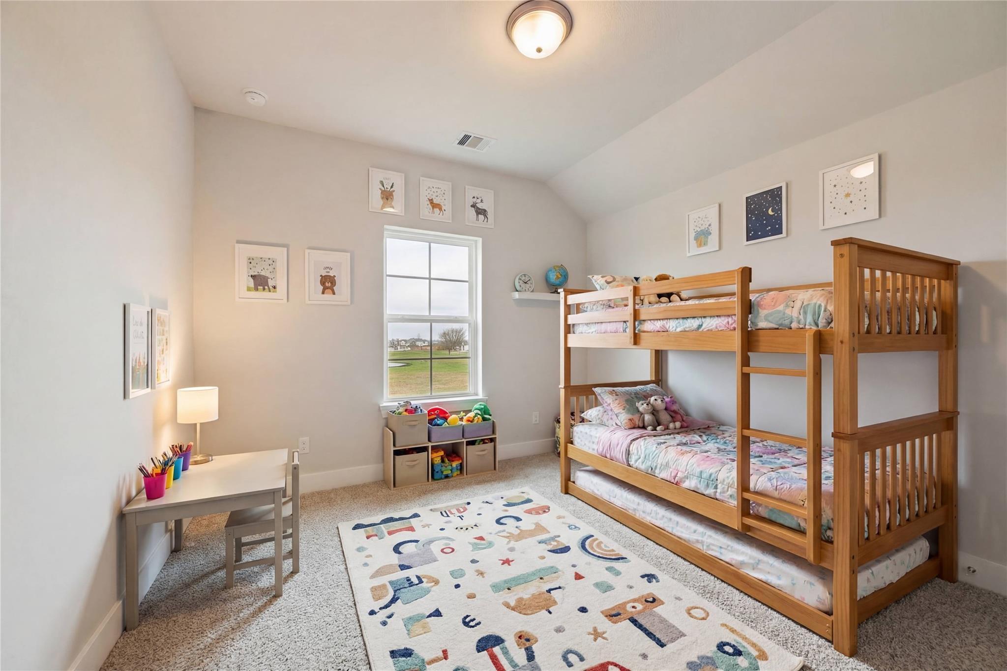 Cozy kids' bedroom with wooden bunk beds, space-themed rug, toy box, and desk in Davidson Homes The Philip A, Lago Mar, Texas City
