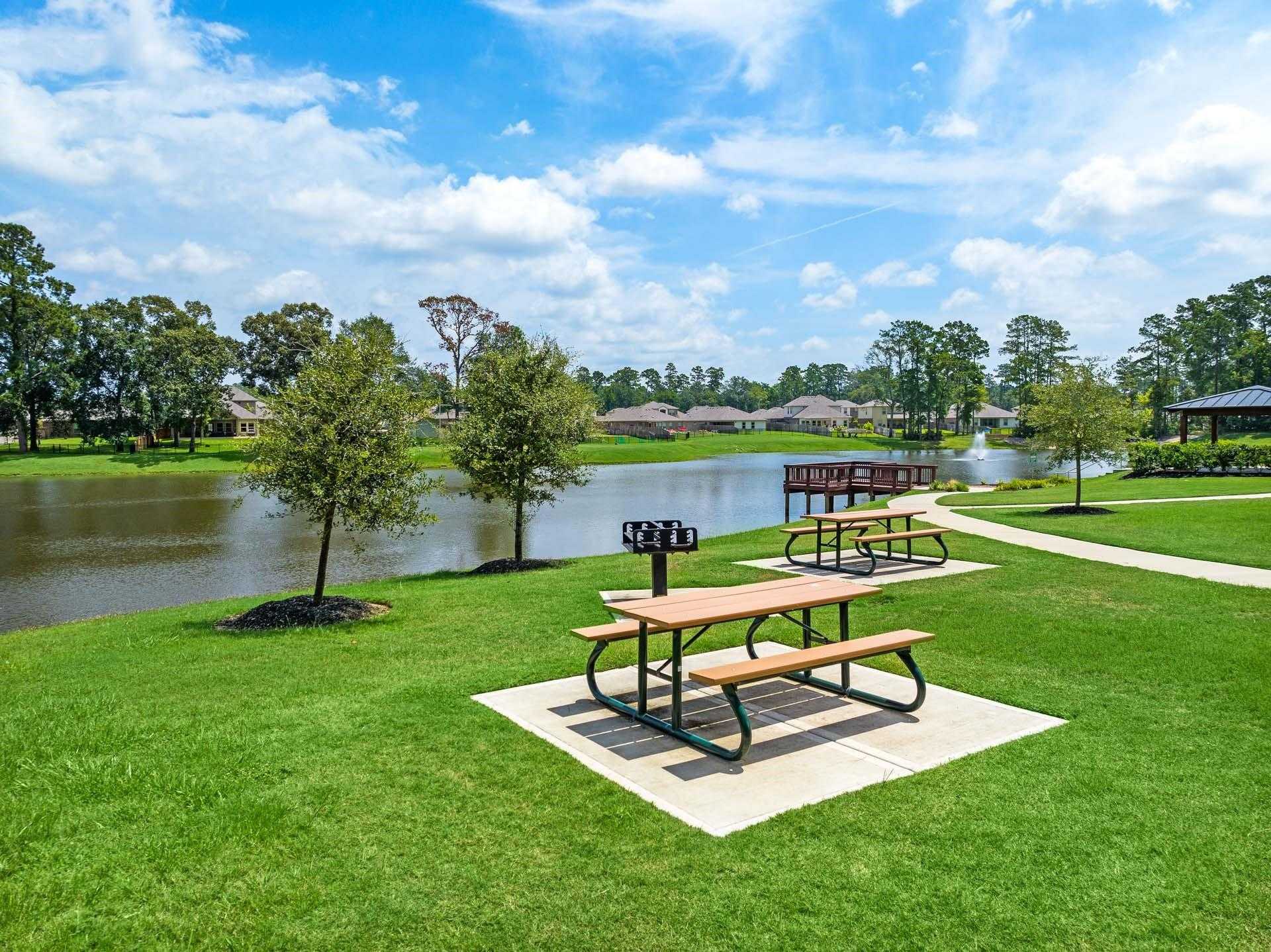 Scenic lakeside park with picnic tables, grill, walking paths, and oak trees in Lakes at Black Oak, Magnolia, Texas