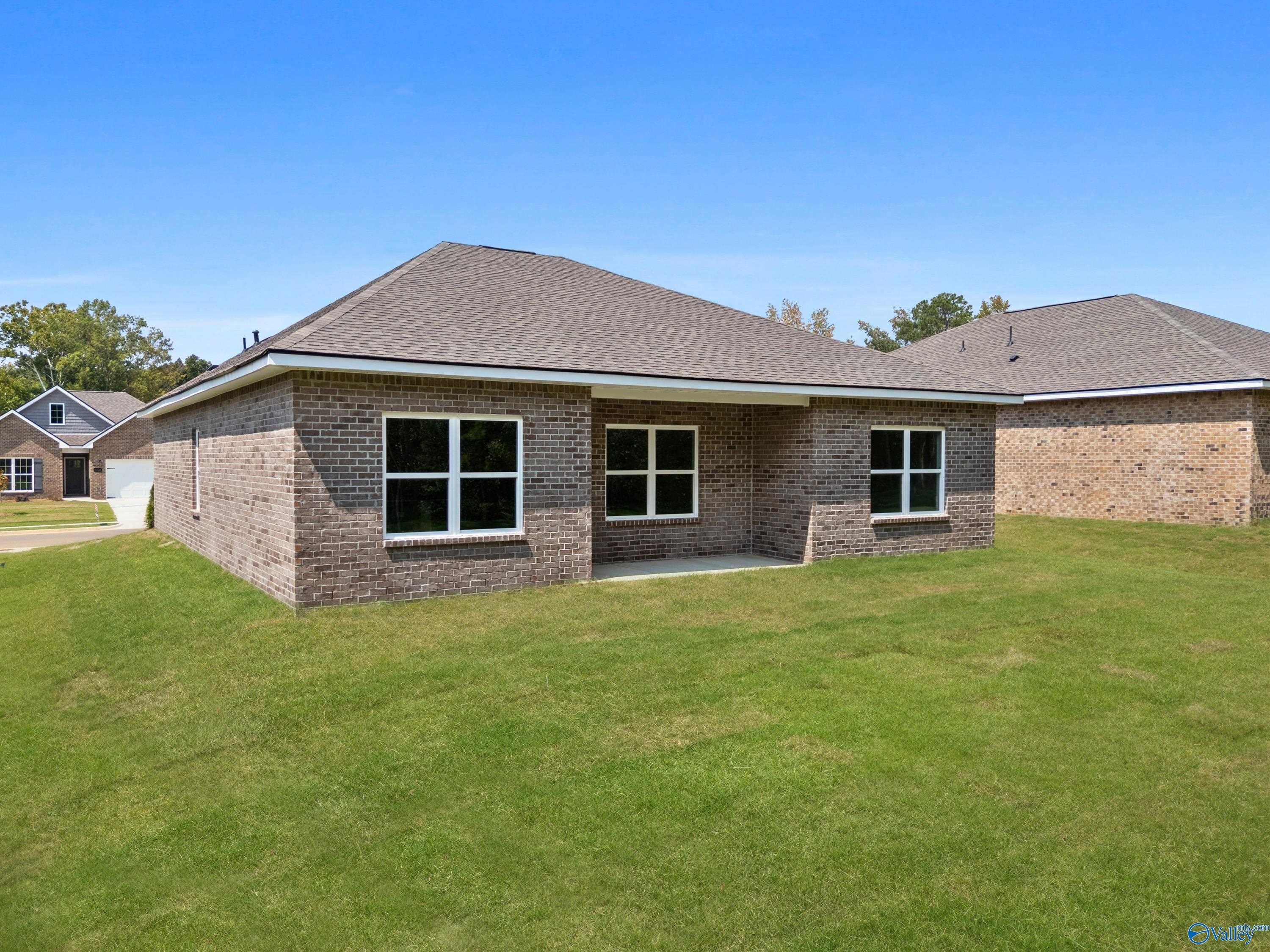 Modern brick 1-story home with covered porch, large windows, and green lawn in Spragins Cove, Huntsville, Alabama