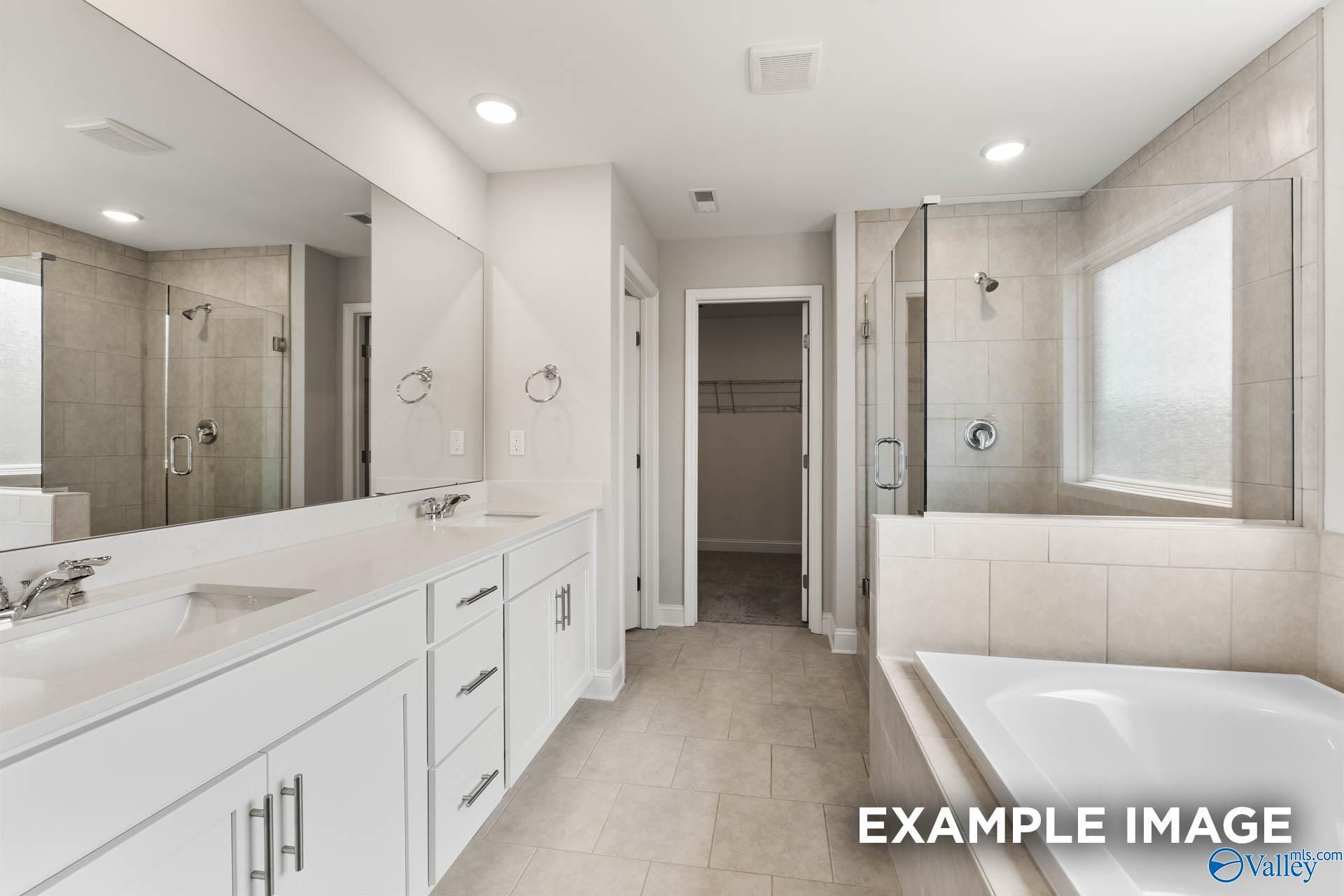 Luxurious master bathroom featuring double vanity, frameless shower, and freestanding tub in Evermore Homes The Madison D, Madison, Alabama