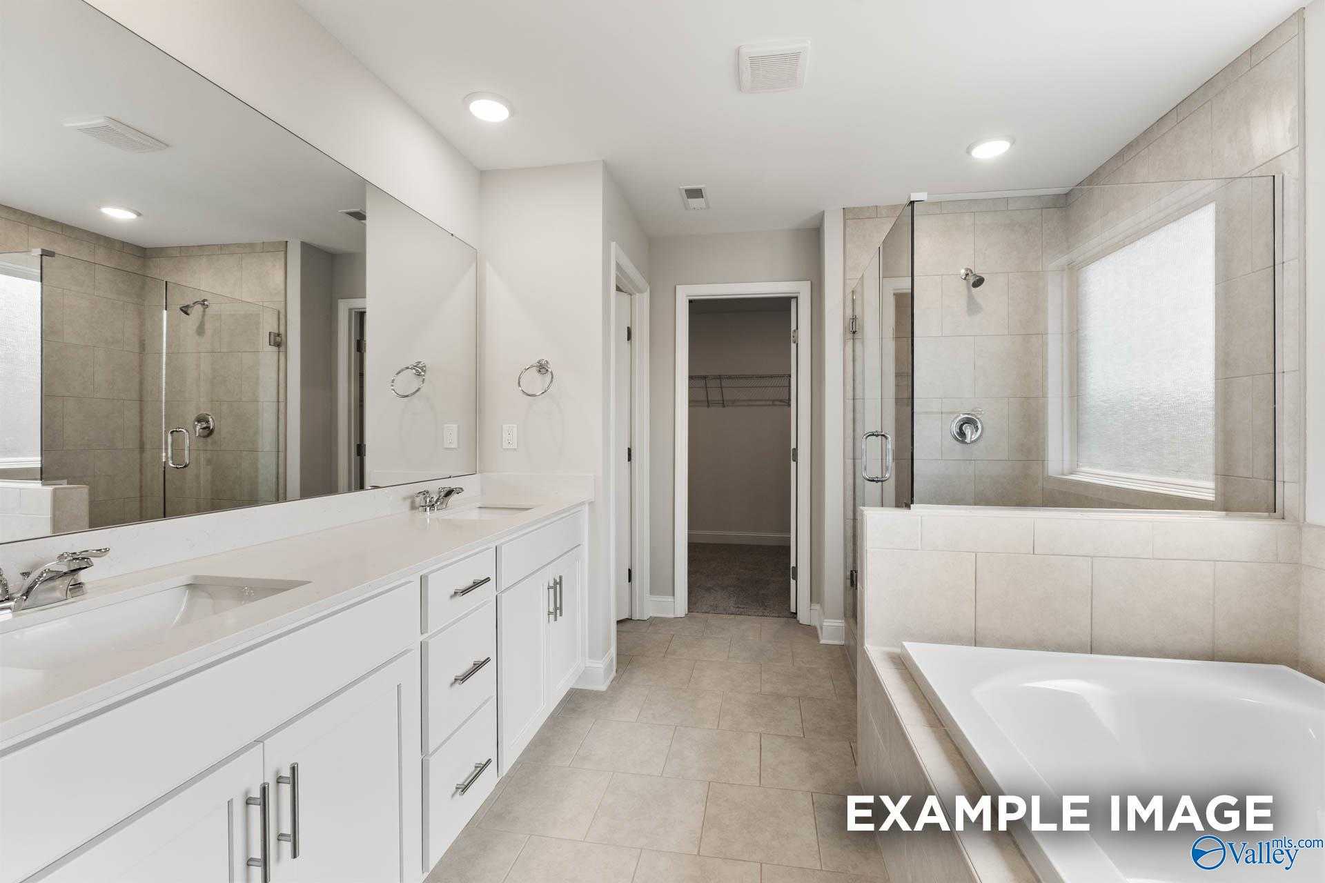Luxurious master bathroom featuring double vanity, frameless shower, and freestanding tub in Evermore Homes The Madison D, Madison, Alabama