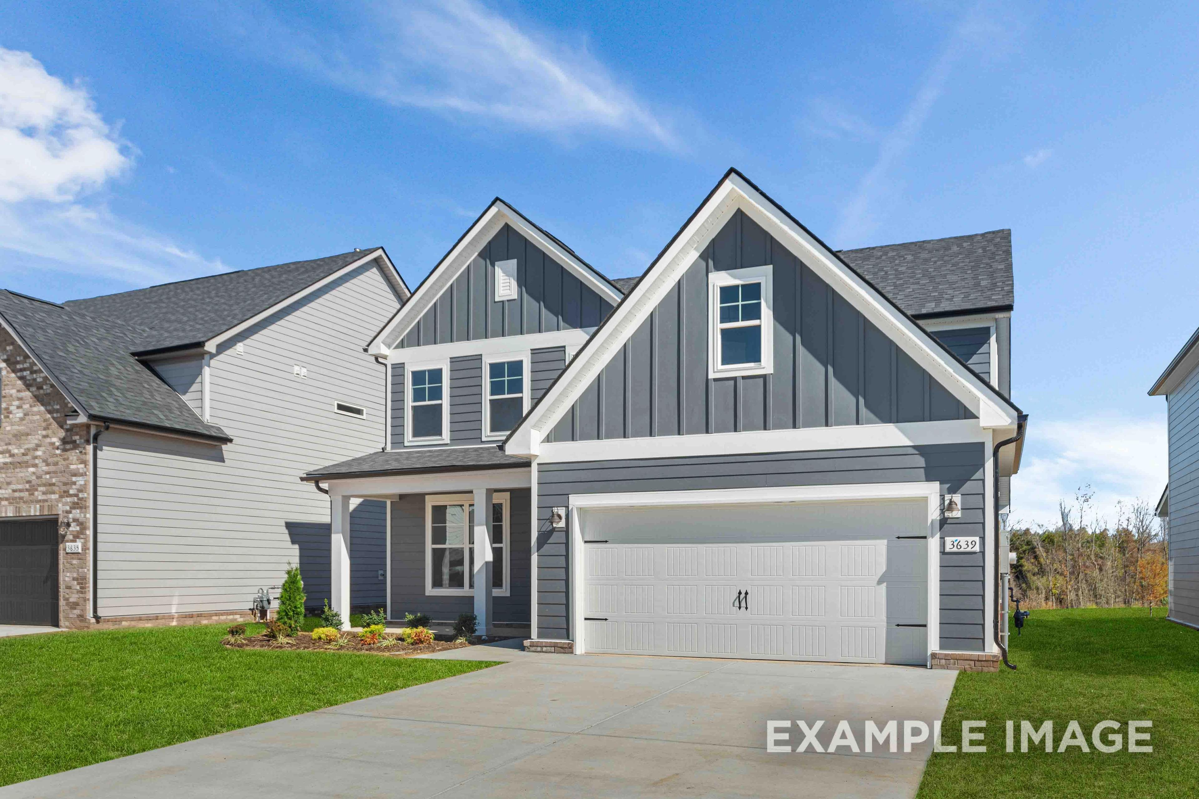 Two-story The Ash home elevation with gray board-and-batten siding, two-car garage, covered porch, and landscaped yard in Mt. Juliet