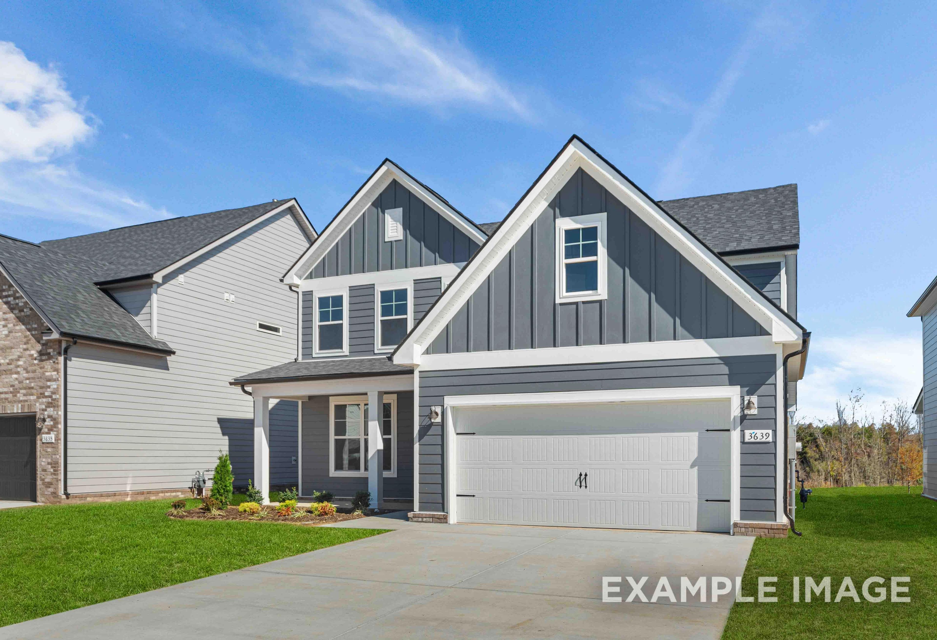 Two-story The Ash home elevation with gray board-and-batten siding, two-car garage, covered porch, and landscaped yard in Mt. Juliet