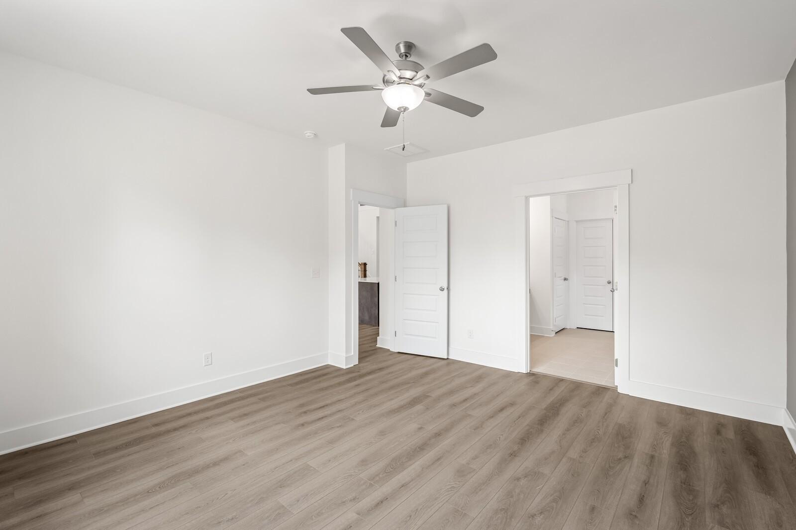 Bright bedroom with wood-look flooring and ceiling fan in The Ridgeport C floor plan at Woods Crossing, Gallatin, TN.