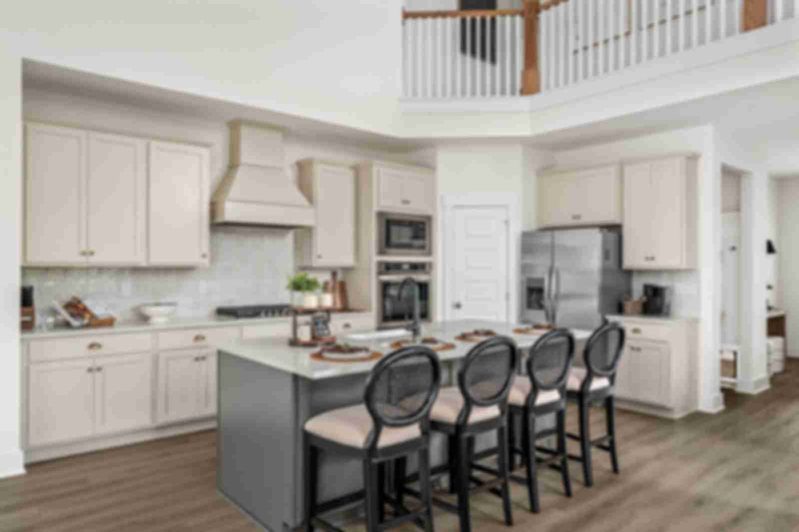 Spacious modern kitchen at Woods Crossing in Gallatin TN with white shaker cabinets, stainless appliances, and gray island bar seating