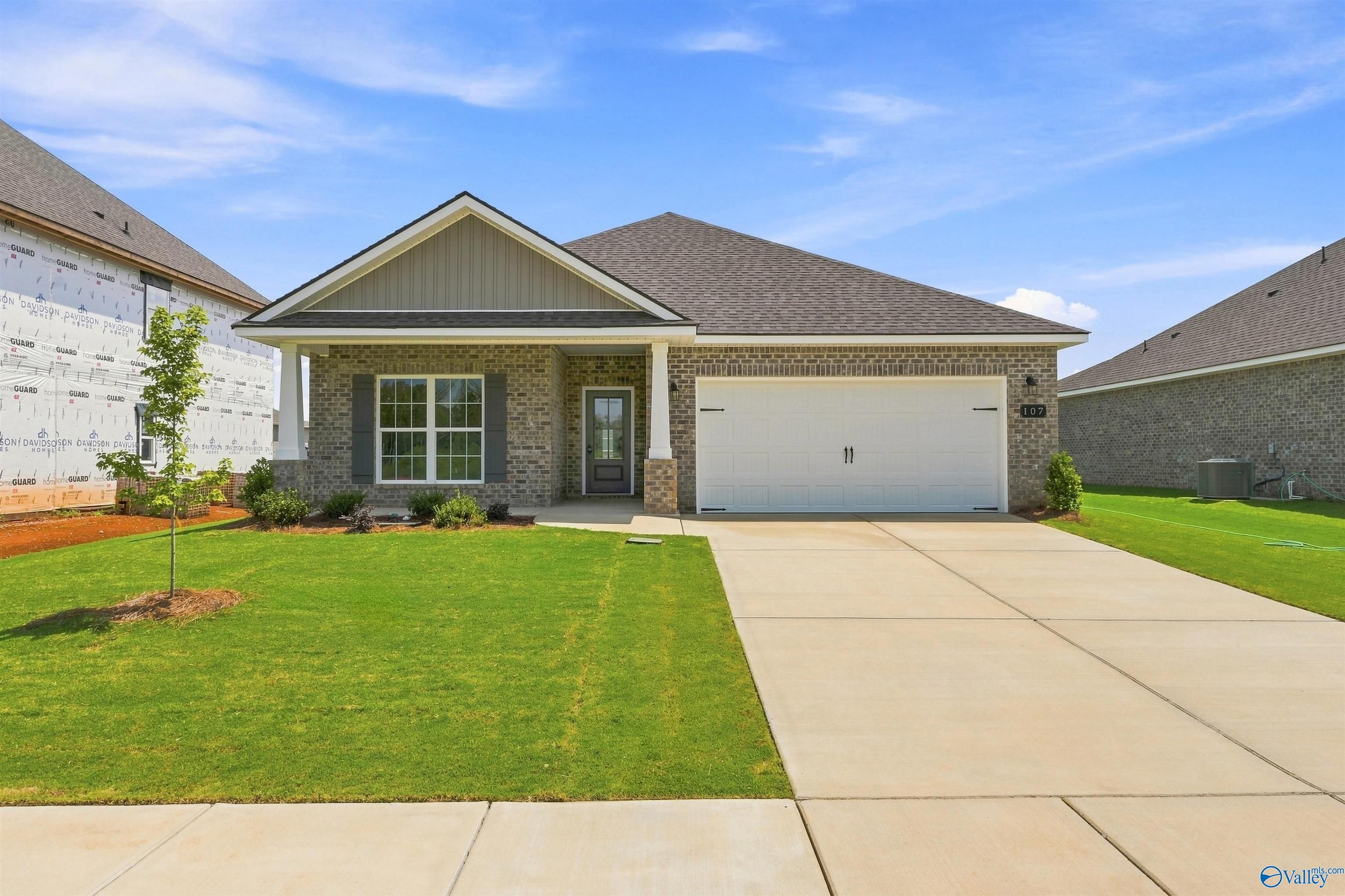 Brick front exterior with 2-car garage and landscaped yard at The Everett B, a Davidson Homes new construction in Wood Trail, Toney, AL