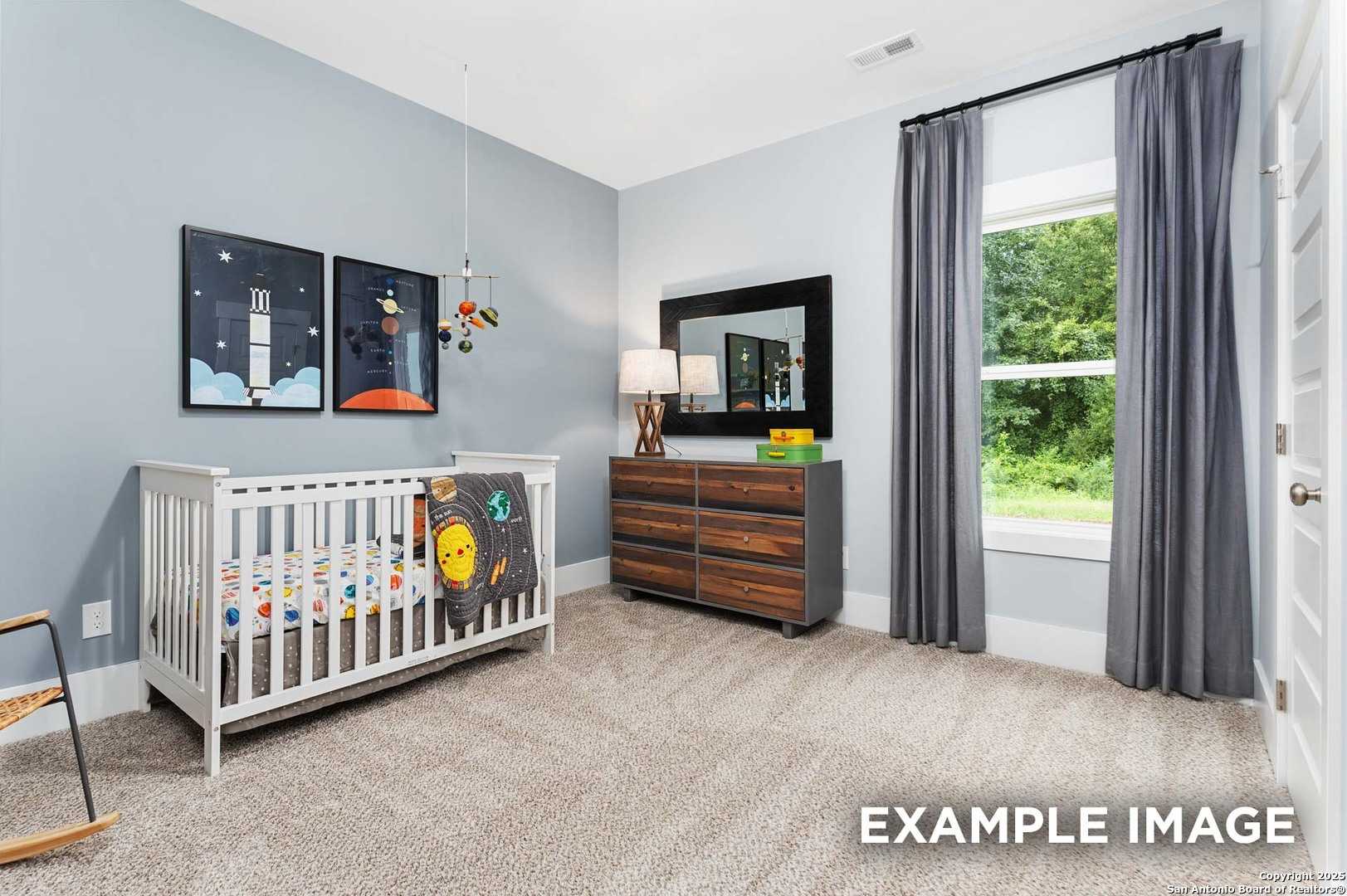 Adorable space-themed nursery with crib, dresser, mirror, and window view in Davidson Homes The Daphne H, Hannah Heights, Seguin, Texas