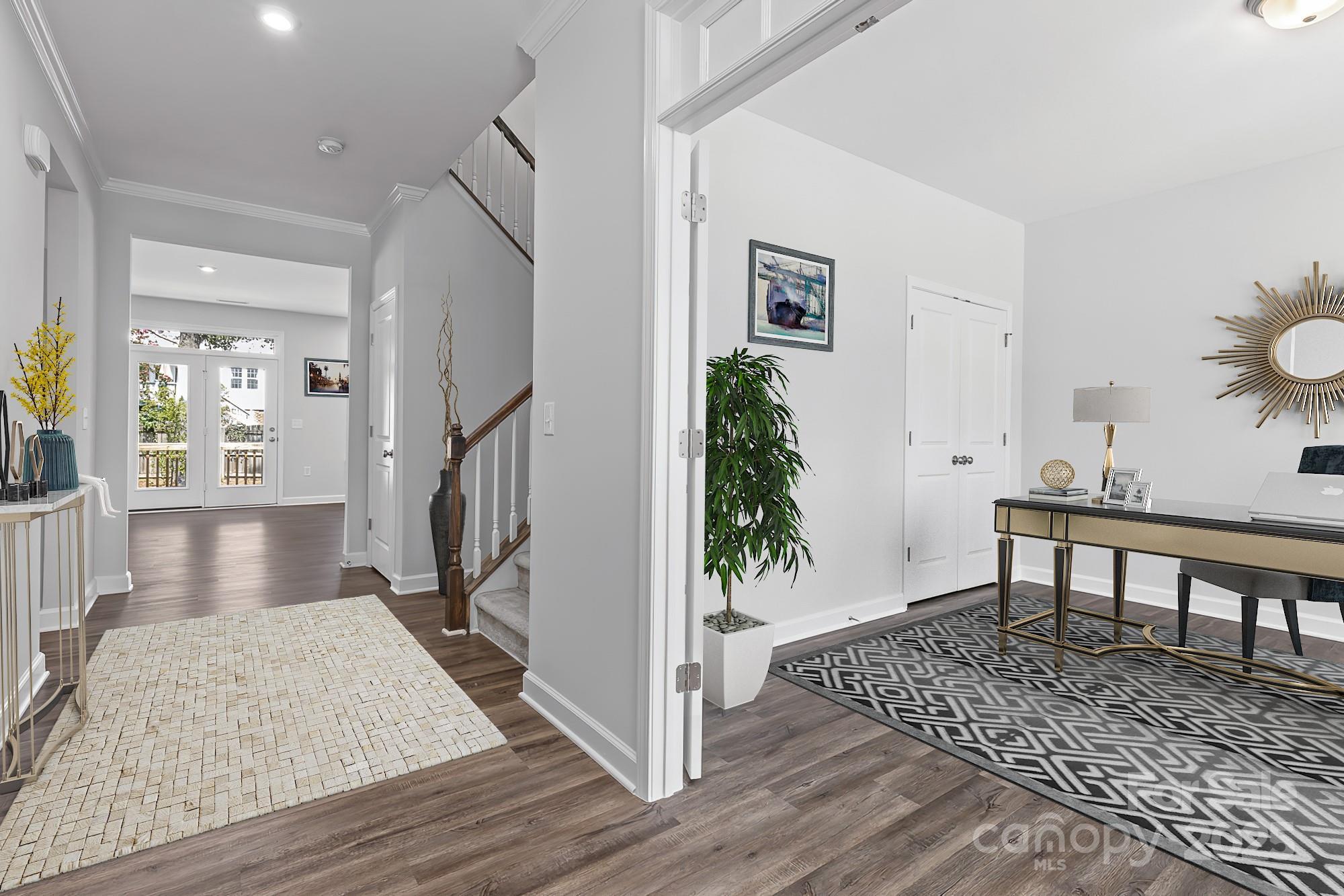 Elegant foyer with hardwood floors, oak staircase, and modern home office desk in Davidson Homes The Hemlock A, Enclave at Belmont