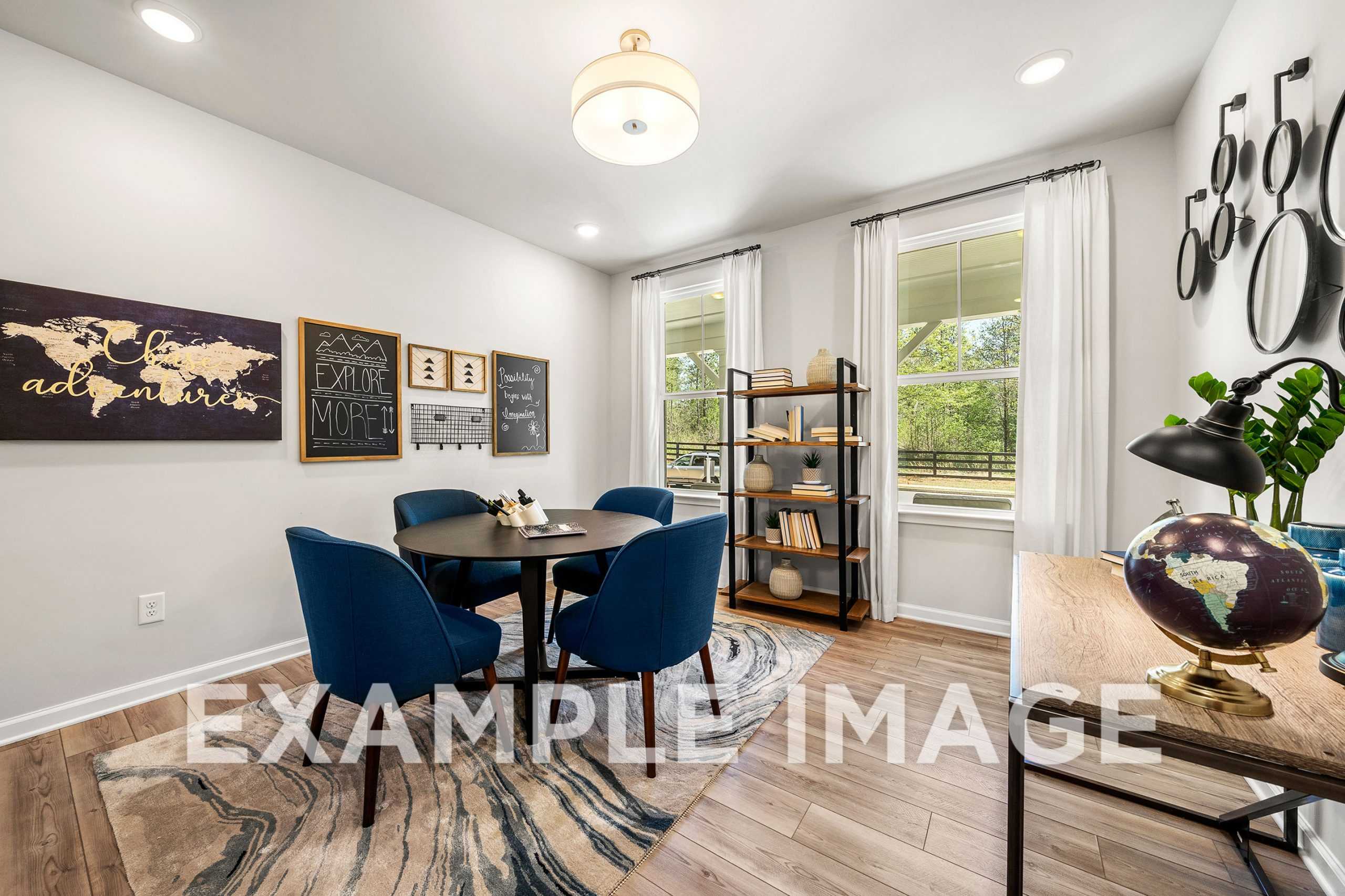 Cozy home office in The Hickory A with navy chairs at round table, world map chalkboard, bookshelf, and globe decor