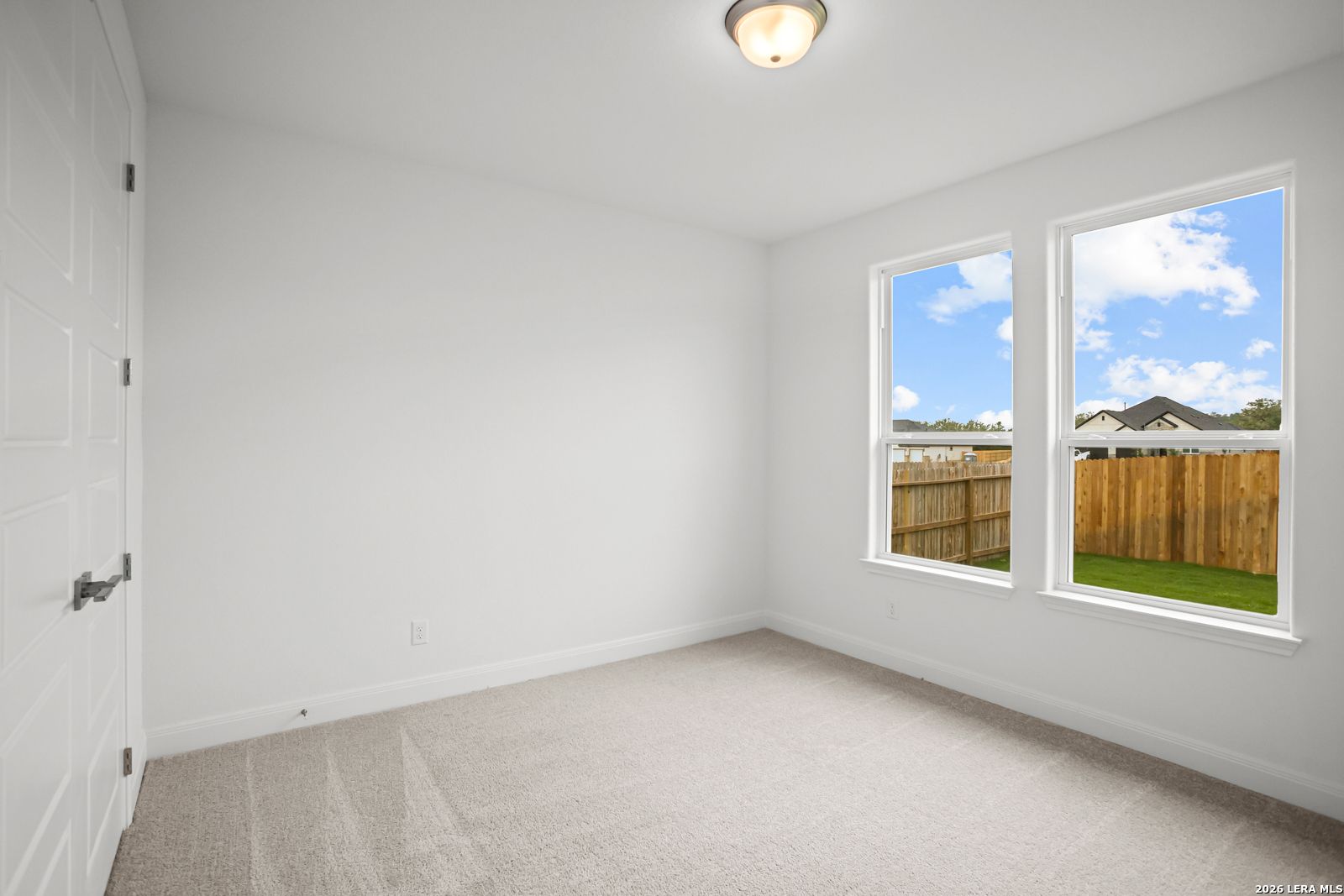 Bright, carpeted bedroom with natural light in The Lanier G floor plan at The Reserve at Potranco Oaks, Castroville, TX.