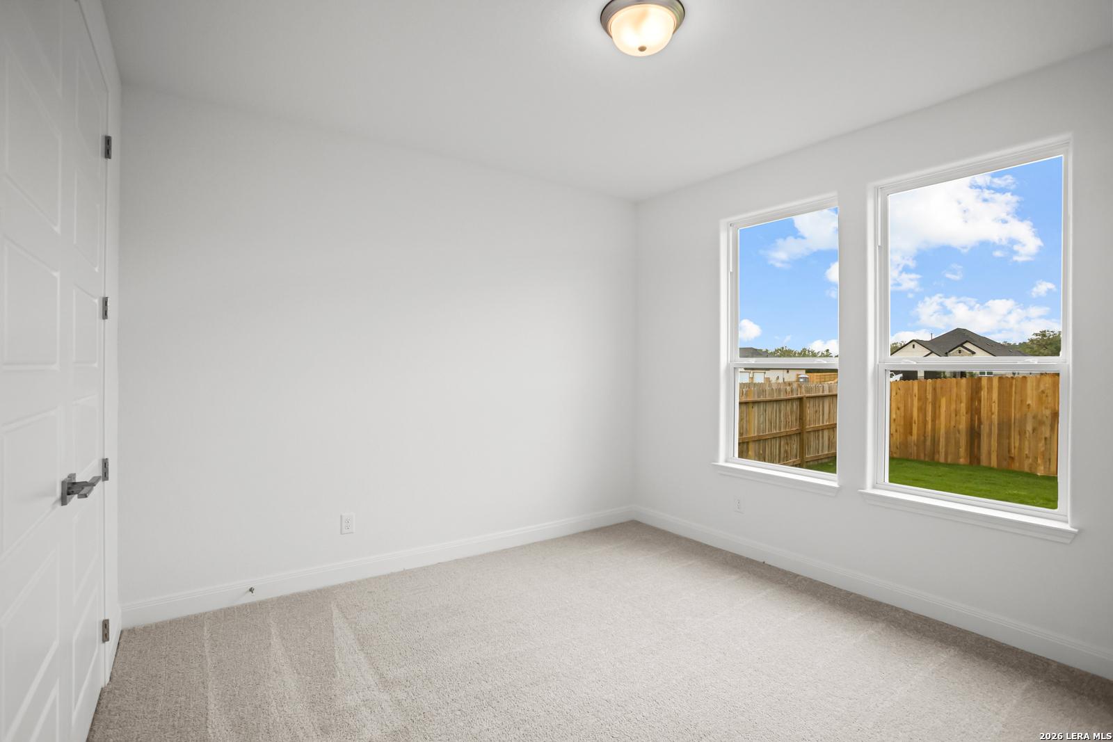 Bright, carpeted bedroom with natural light in The Lanier G floor plan at The Reserve at Potranco Oaks, Castroville, TX.