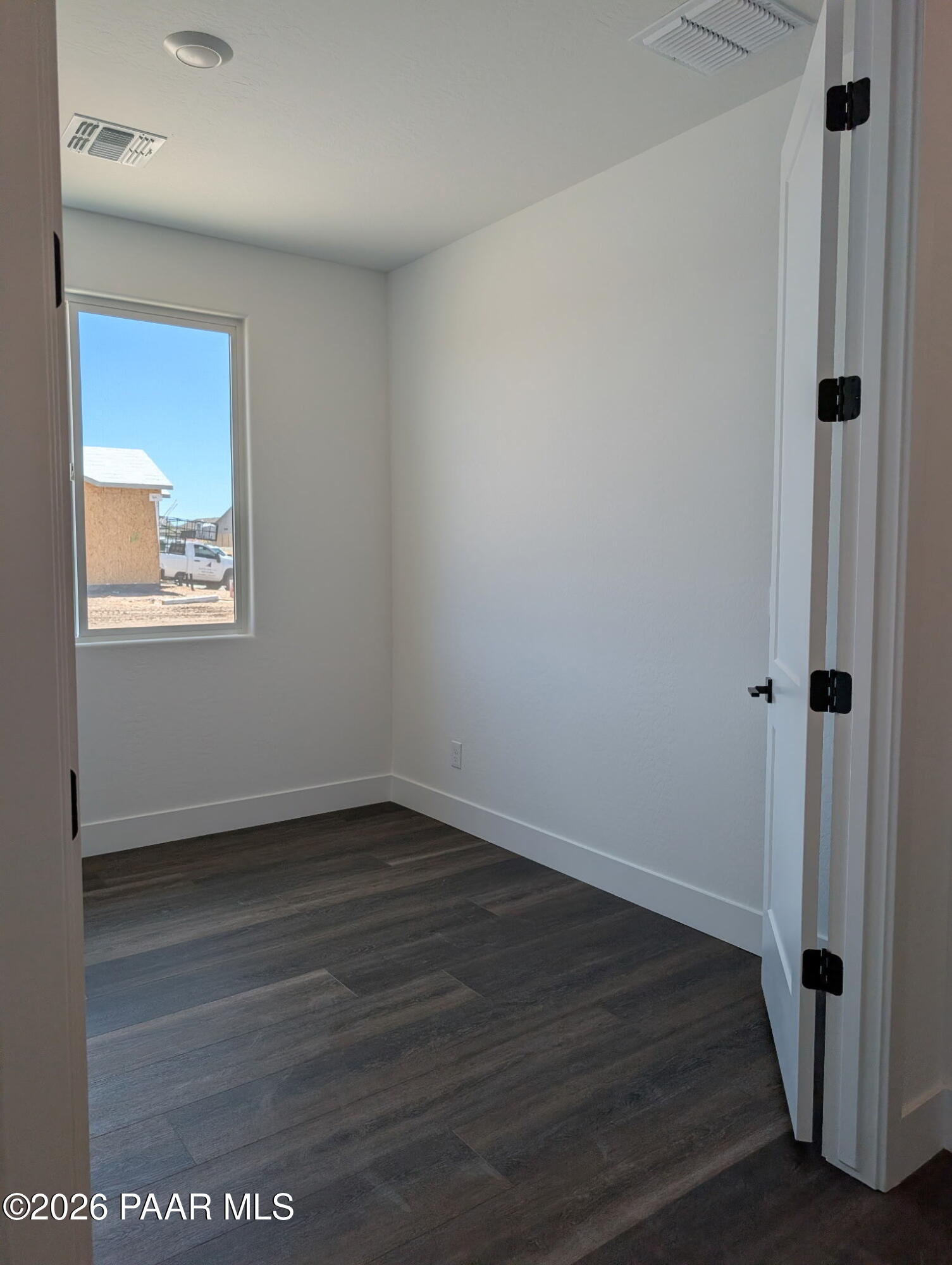 Bright, unfurnished bedroom with wood-look flooring in The Frontier II F floor plan at South Ranch, Prescott, Arizona.