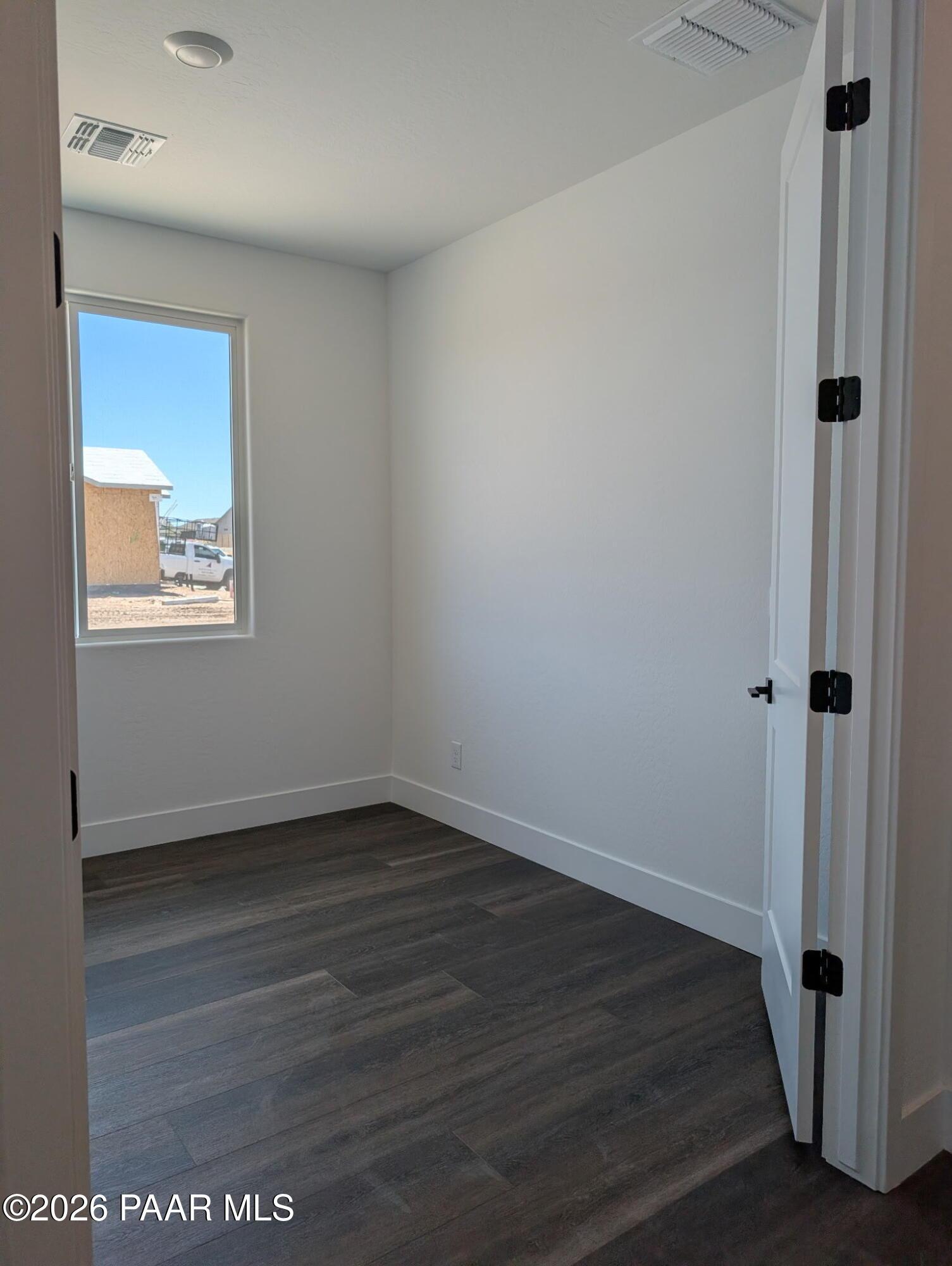 Bright, unfurnished bedroom with wood-look flooring in The Frontier II F floor plan at South Ranch, Prescott, Arizona.
