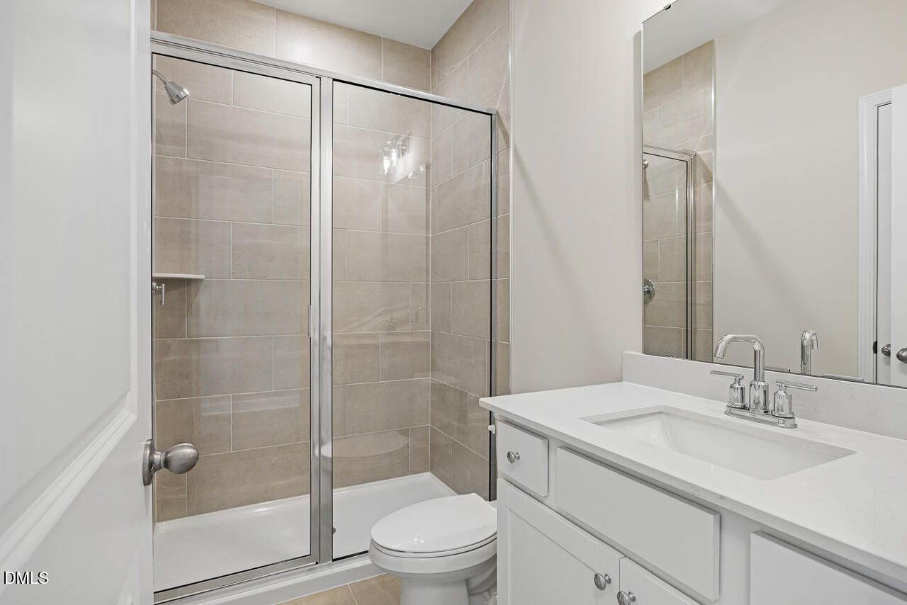 Modern bathroom with tiled glass shower and white vanity in The Chestnut floor plan home in Montrose, Aberdeen, NC.