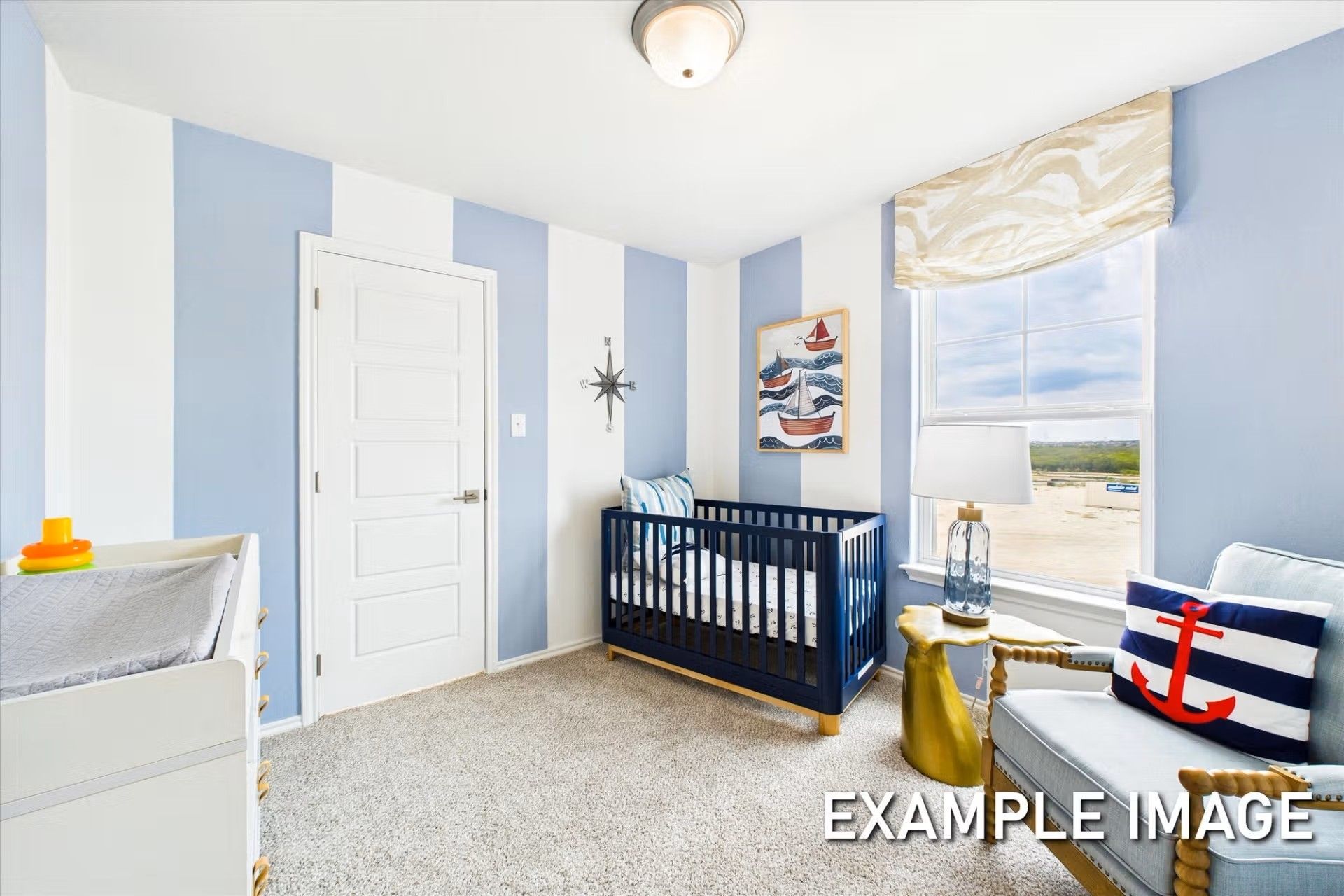 Nautical-themed nursery with blue-and-white striped walls in The Brazos E floor plan at Heartland, Heartland, Texas.