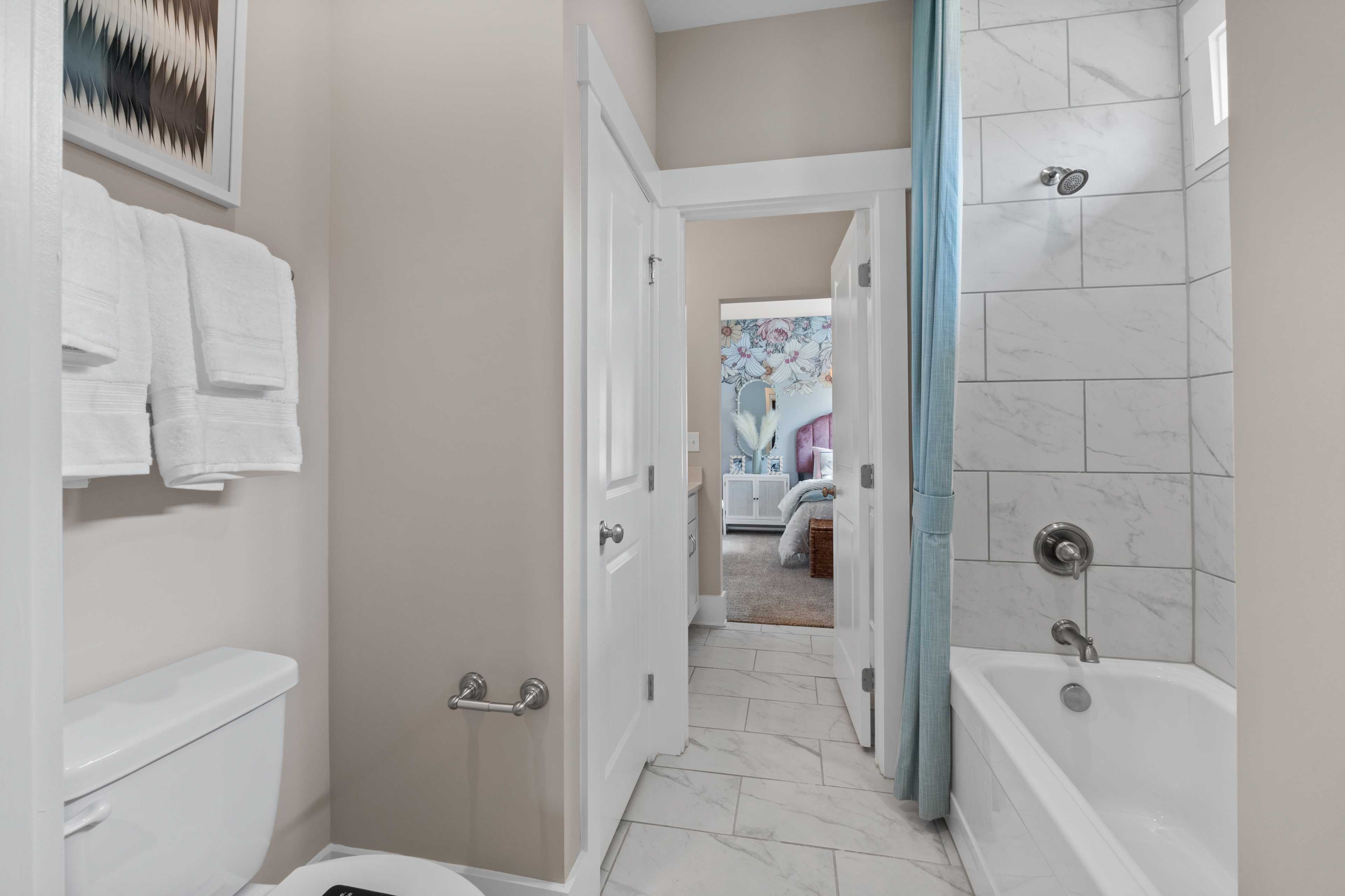 Spacious master bathroom at Creekside in Harvest Alabama with white subway tile, soaking tub, and bedroom view