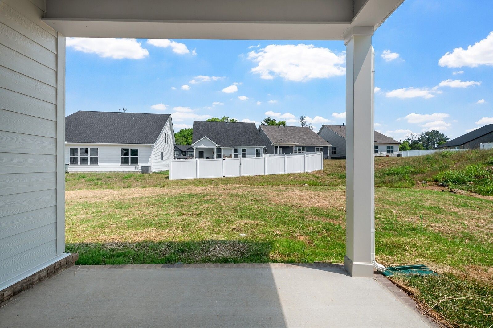 Covered concrete patio overlooking a grassy backyard in the Woods Crossing community of Gallatin, Tennessee.
