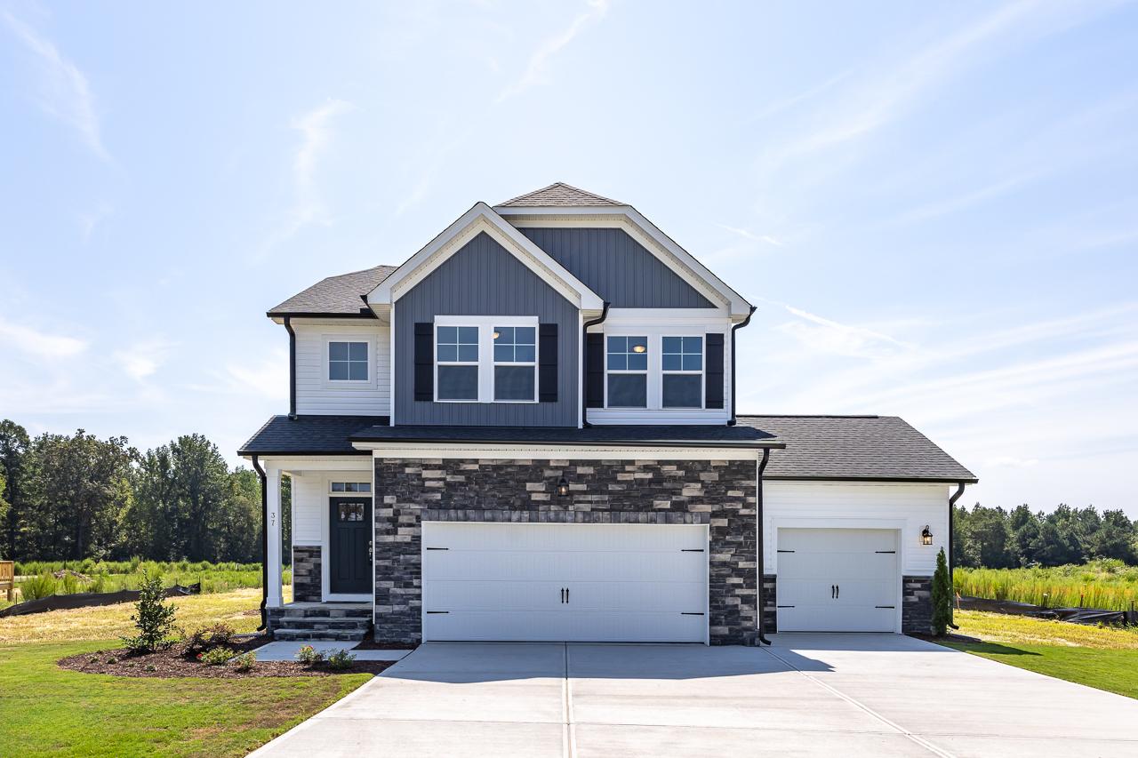 Contemporary two-story home exterior at Wellers Knoll in Lillington NC with gray siding, covered porch, and two-car garage
