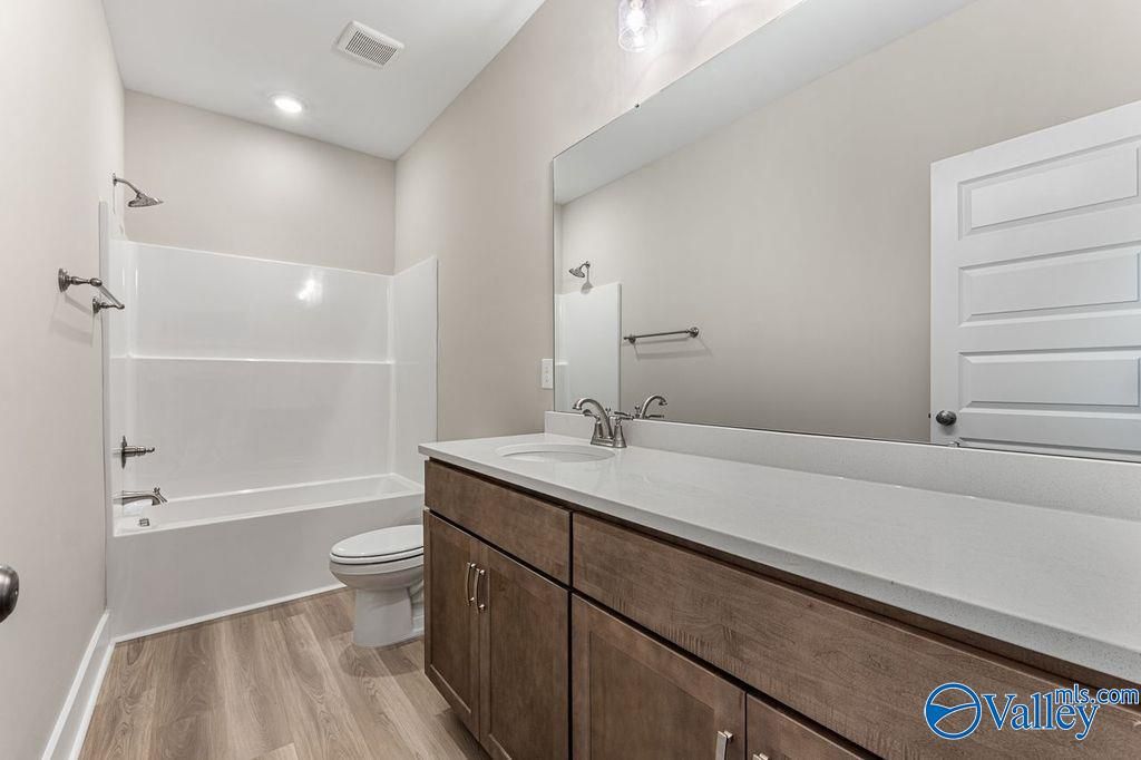 Modern bathroom with tub-shower combo, double quartz vanity, large mirror in Evermore Homes The Oxford, Owens Cross Roads, AL