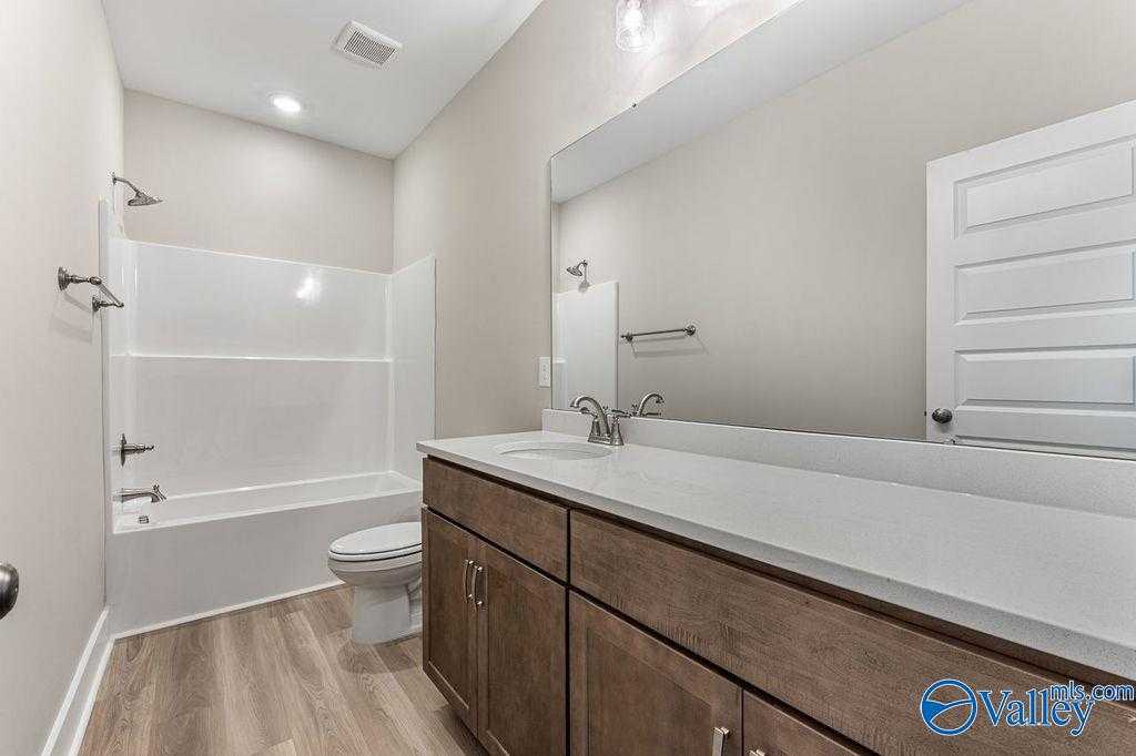 Modern bathroom with tub-shower combo, double quartz vanity, large mirror in Evermore Homes The Oxford, Owens Cross Roads, AL