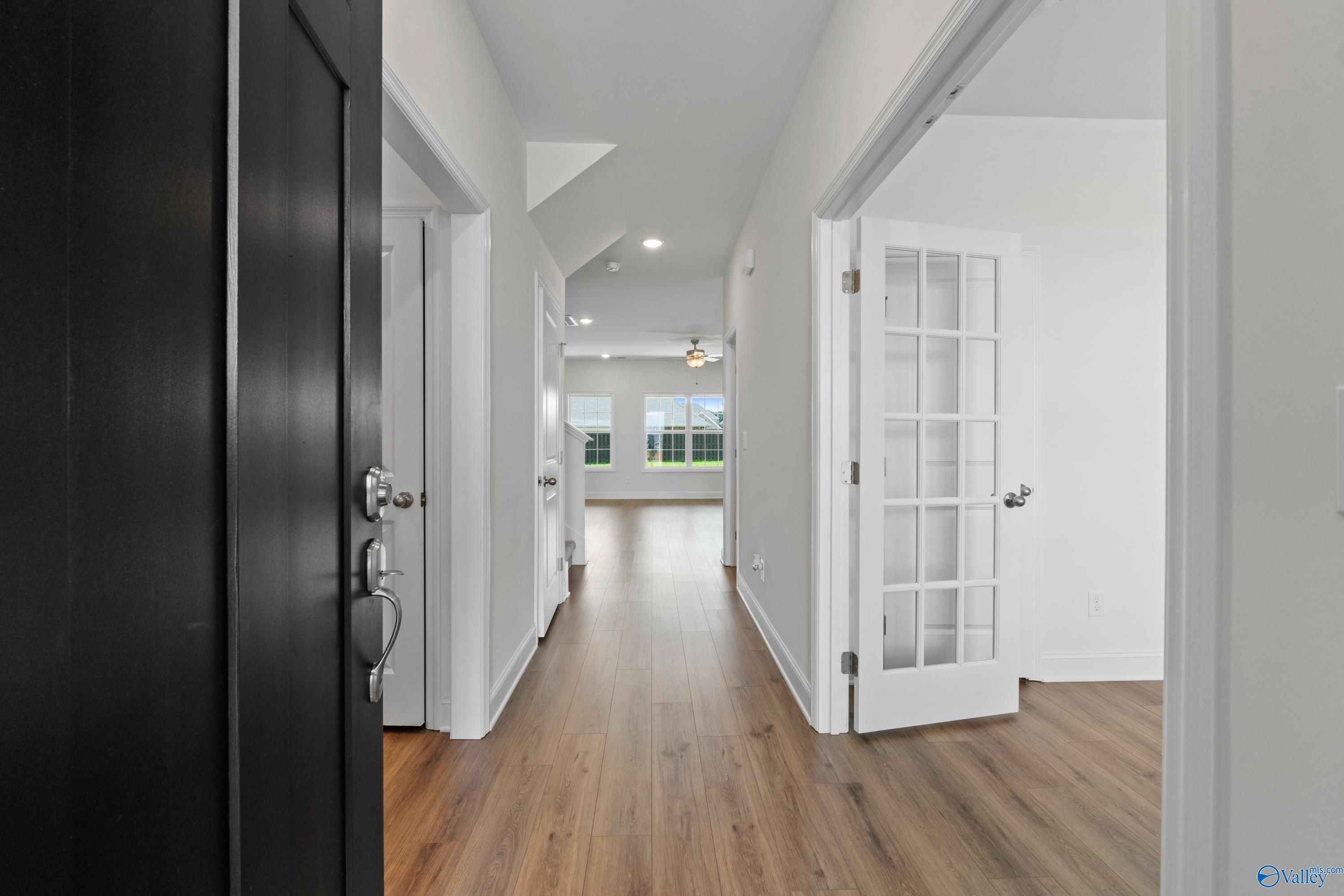 Bright hallway with oak hardwood floors, French doors, and natural light in Davidson Homes Rockford B, Kendall Downs, Toney, AL