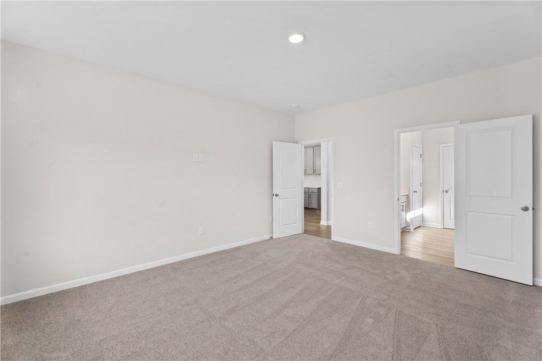 Spacious master bedroom with en-suite bath and closet doors in Davidson Homes The Luna B, Opelika, Alabama