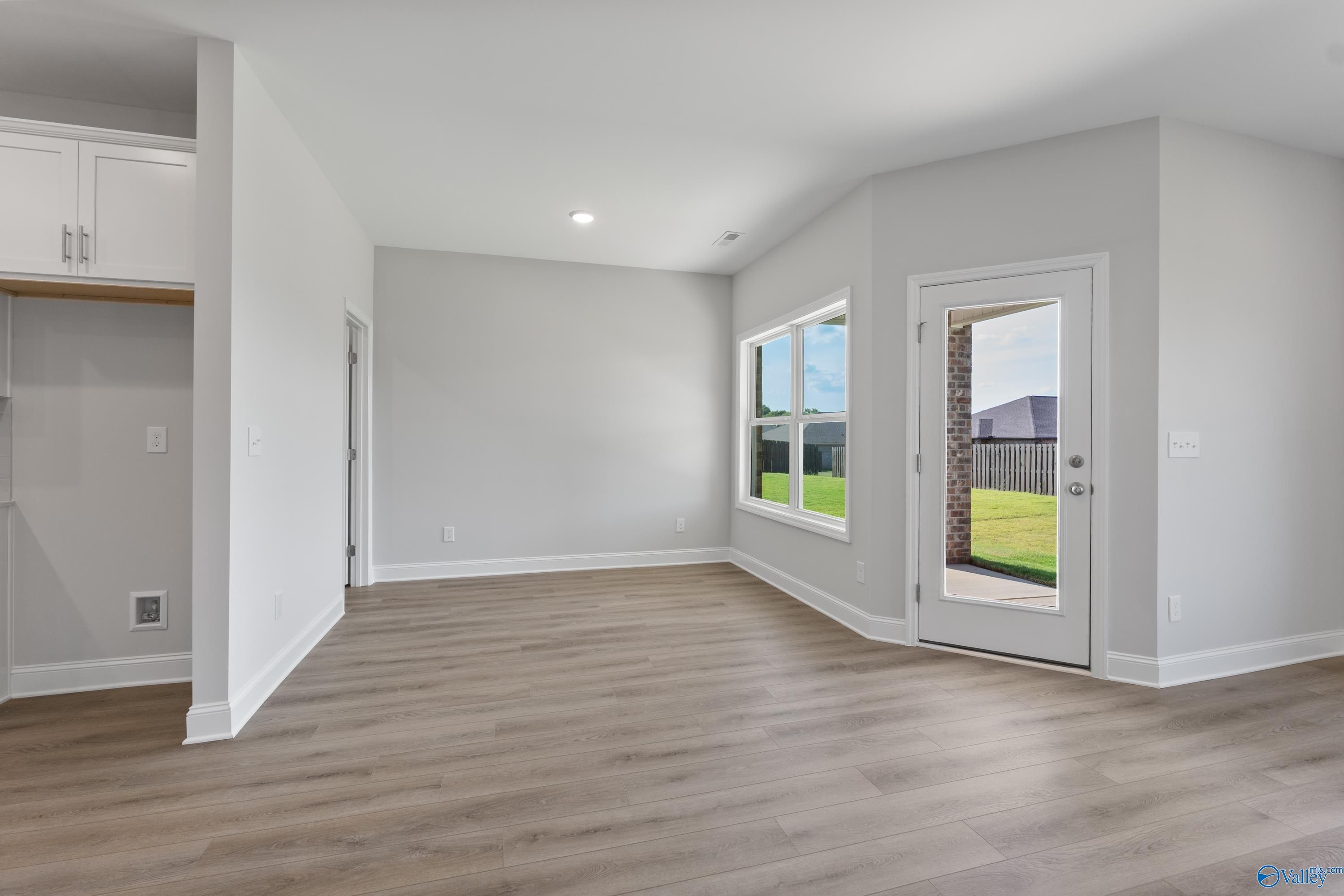 Bright open living room with sliding glass doors to lush backyard in Davidson Homes The Daphne, Hazel Green, Alabama