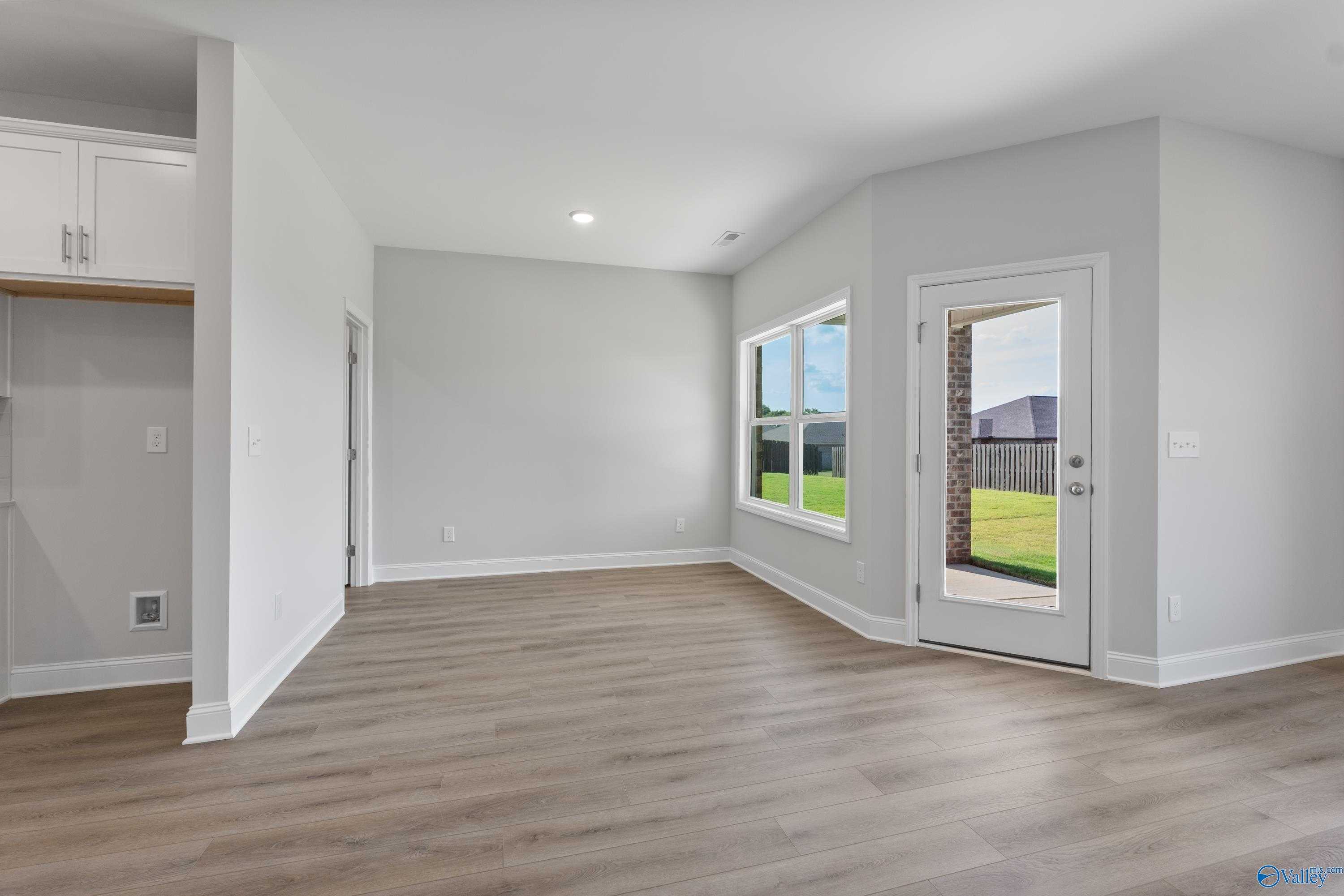 Bright open living room with sliding glass doors to lush backyard in Davidson Homes The Daphne, Hazel Green, Alabama
