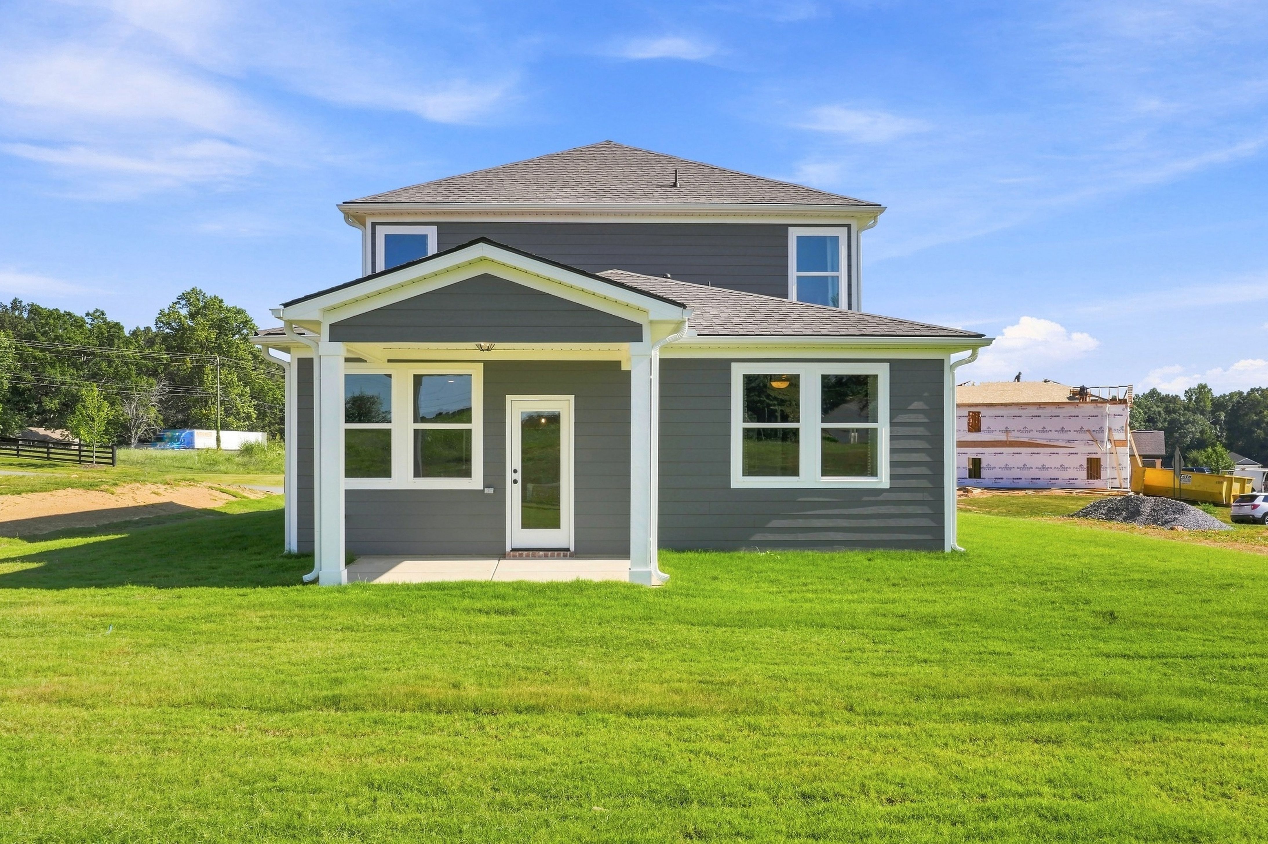 Gray two-story new construction home with covered back porch at Bailey Park by Davidson Homes in Fayetteville, Tennessee