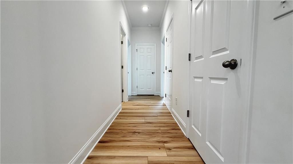 Bright hallway with wood-look flooring in The Glenwood A floor plan at Wehunt Meadows in Hoschton, Georgia.