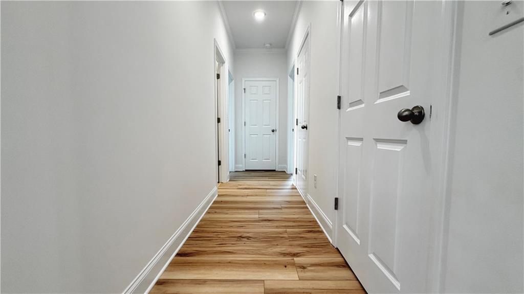 Bright hallway with wood-look flooring in The Glenwood A floor plan at Wehunt Meadows in Hoschton, Georgia.
