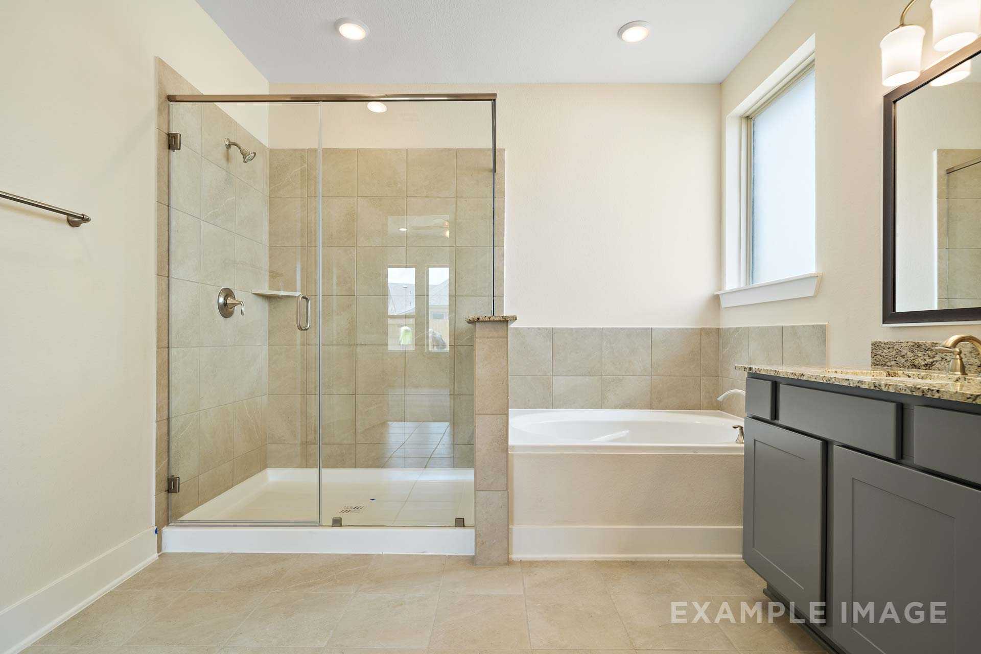 Spacious master bathroom in The Diana C featuring glass-enclosed walk-in shower, freestanding tub, and double vanity