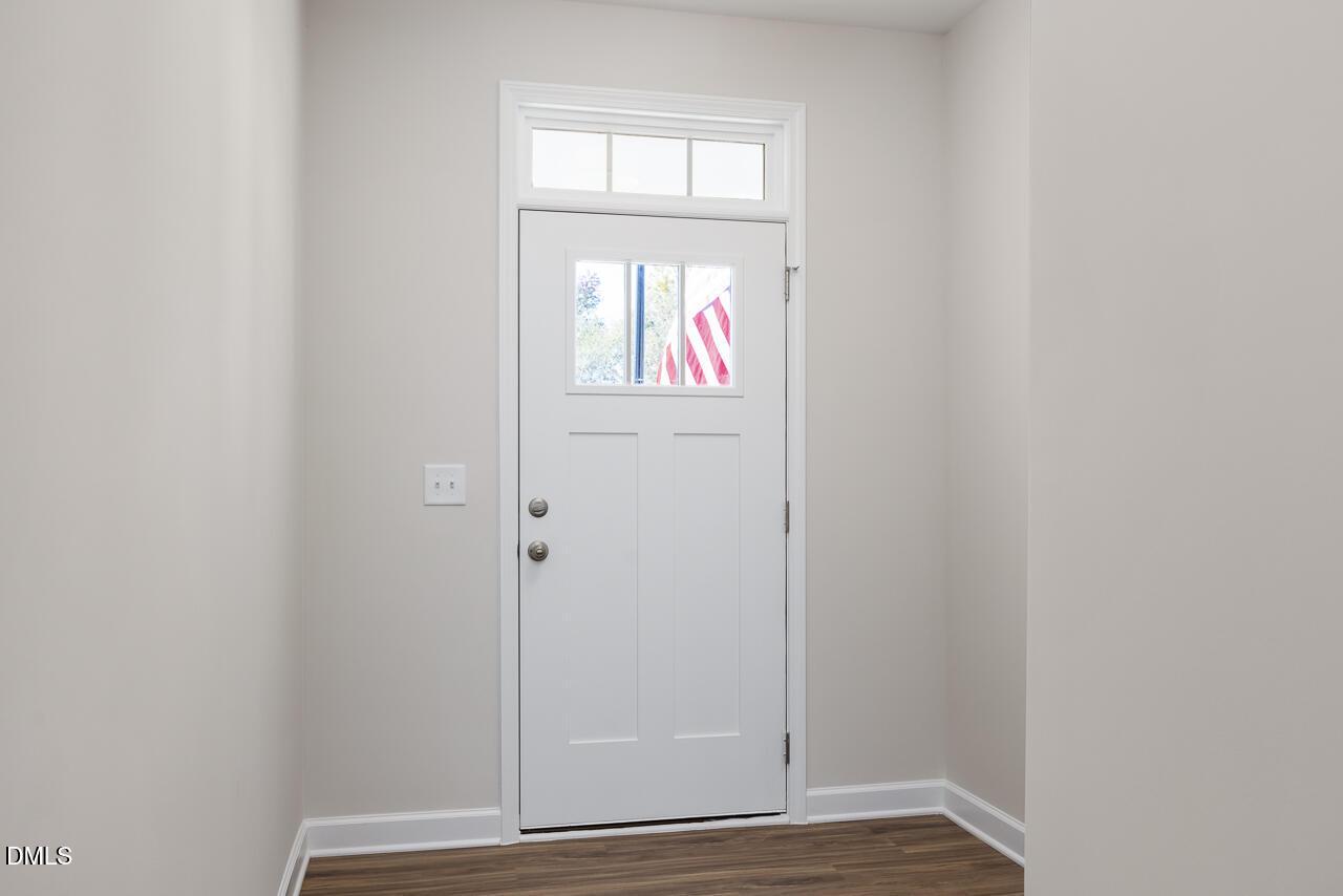 White front door with glass panels and American flag view in entryway of Davidson Homes The Grace C in Lillington, NC