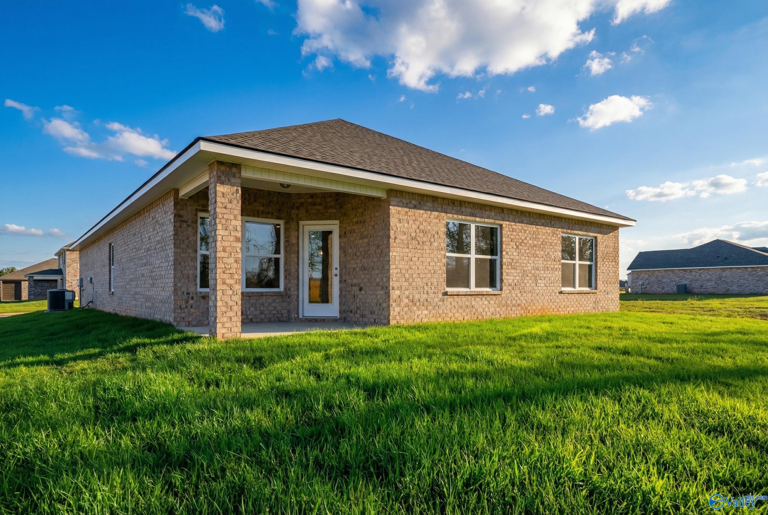 Brick single-story home with covered front porch, large windows, and green lawn in Ivy Hills, Toney, Alabama - Davidson Homes The Daphne C