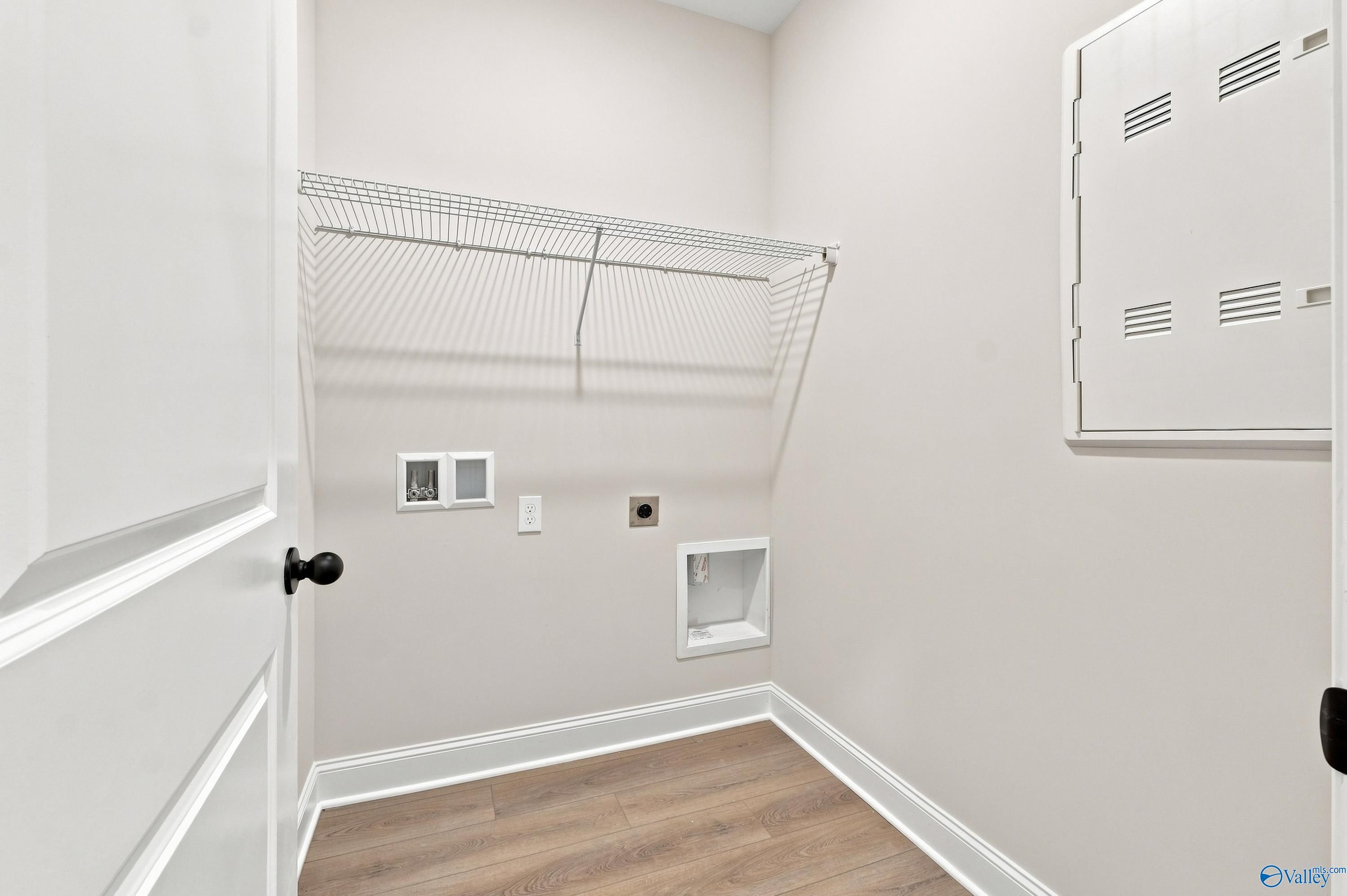 Laundry room with wire shelving and utility hookups in The Asheville E floor plan by Davidson Homes in Hazel Green, AL.