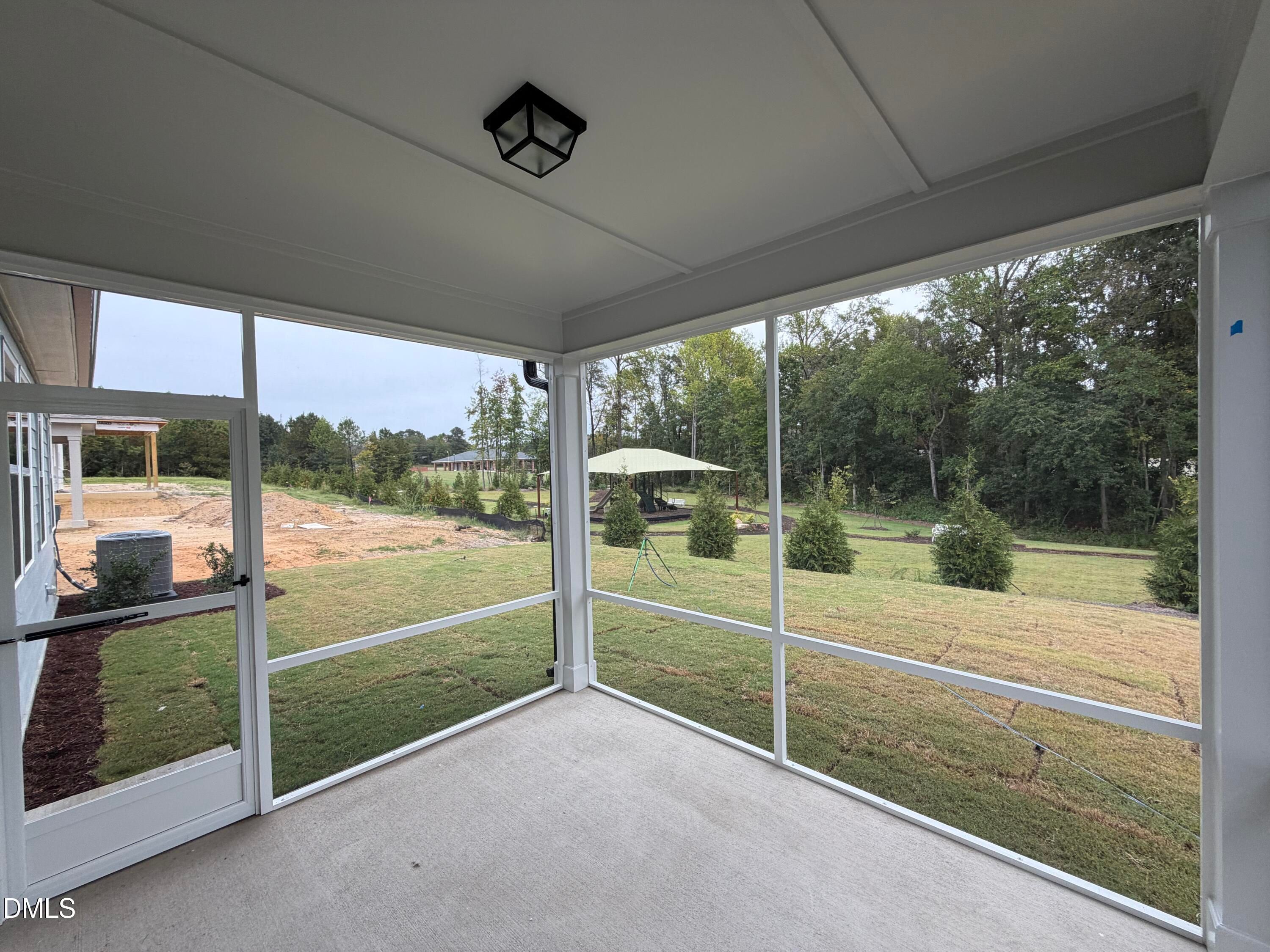 Screened back porch with vaulted ceiling overlooking backyard in Davidson Homes The Ashport M, Wendell Ridge, North Carolina