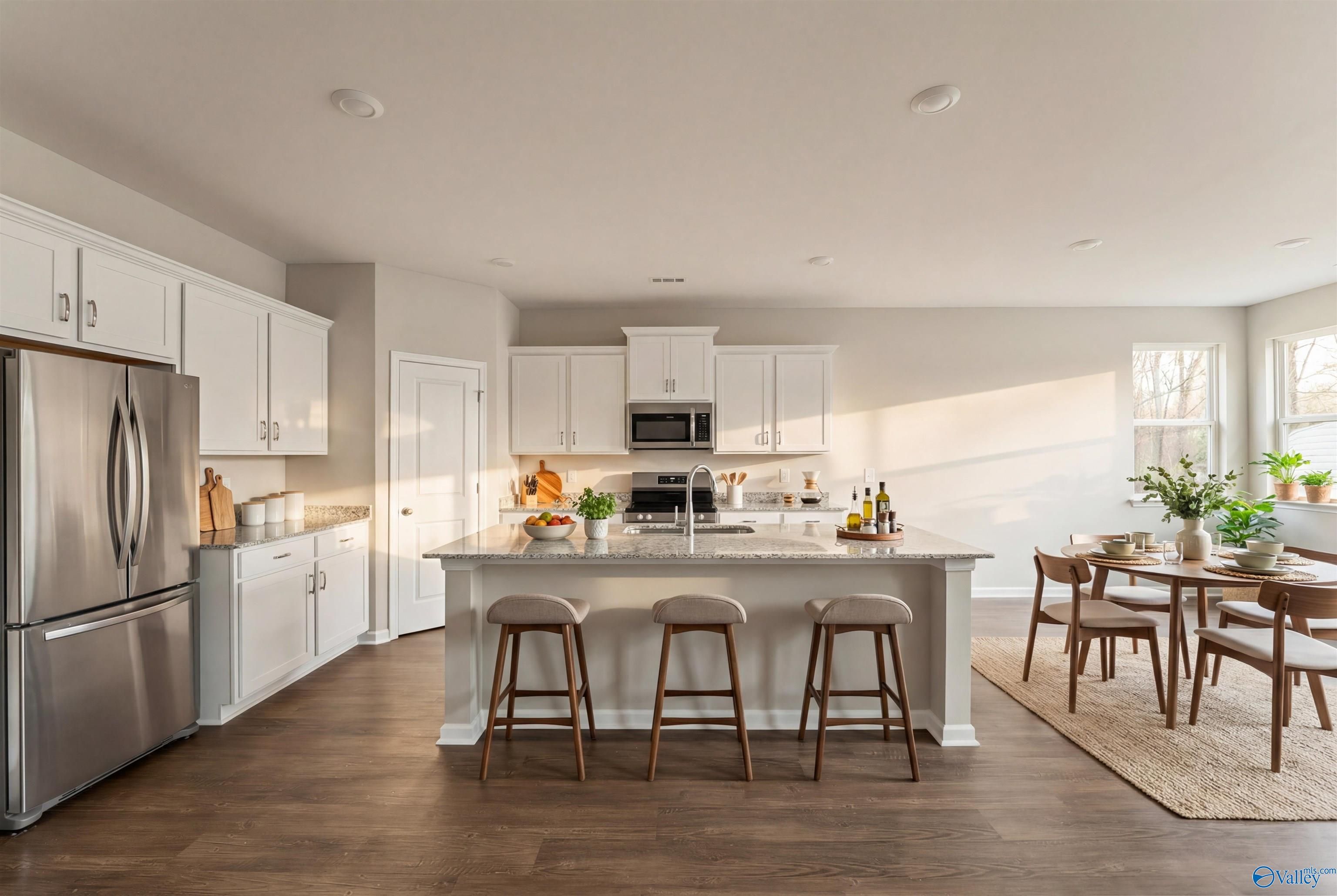Modern open-concept kitchen with white shaker cabinets, quartz island, stainless appliances in Davidson Homes The Phoenix, Fayetteville, TN