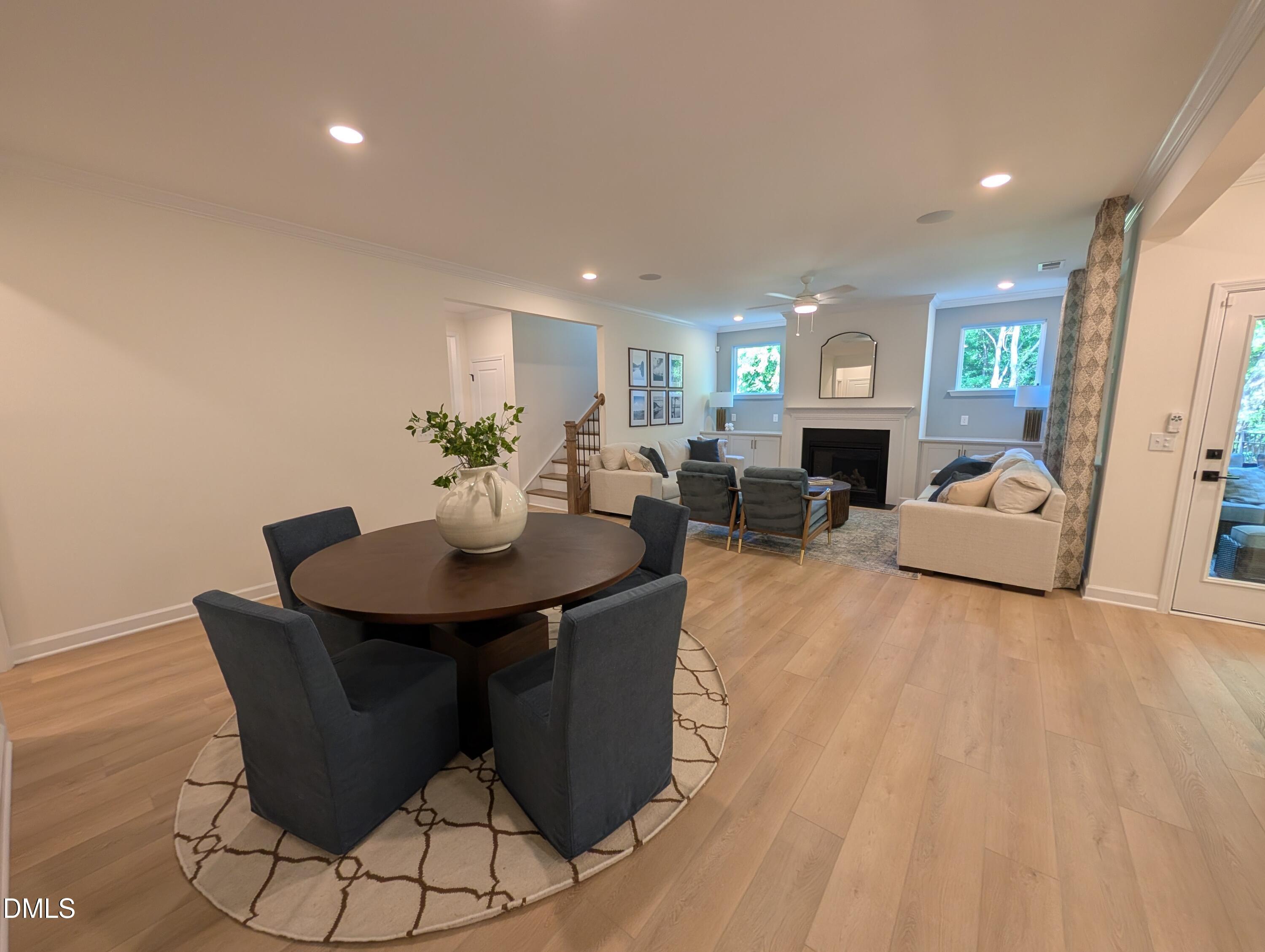 Open-concept dining and living area with fireplace in The Aspen B floor plan at Wendell Ridge in Wendell, North Carolina.
